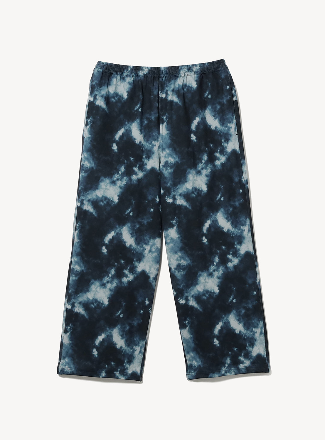 The BEAMS Wide Straight Fit Dynamic Dry Easy Pants are loose-fitting, lightweight technical pants with an elastic waistband, showcasing a dark blue and white tie-dye pattern. The wide silhouette pants are displayed laid flat on a white background.