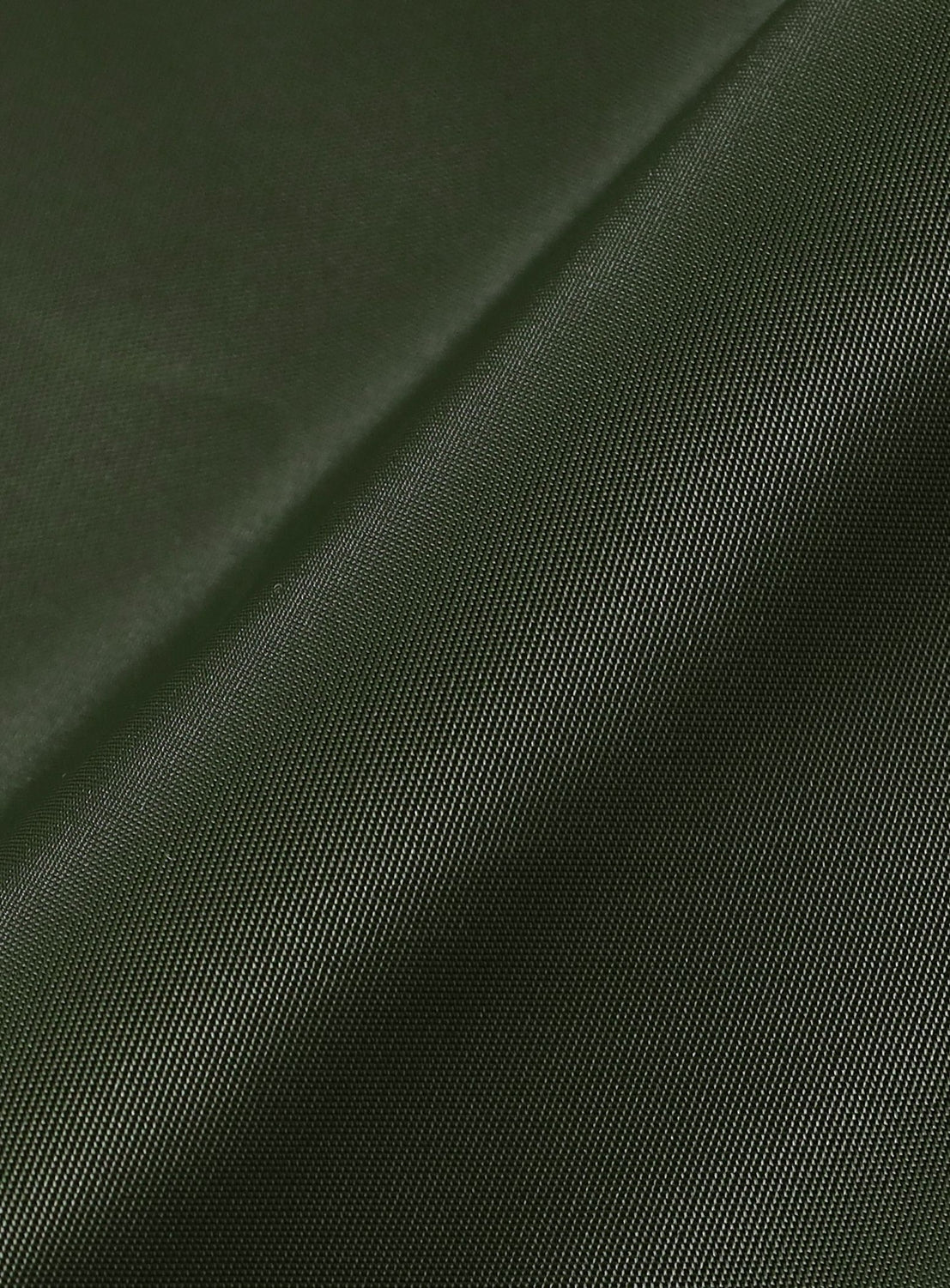 Close-up of the dark green, textured Bandana Embroidered Flight Jacket by NOMARHYTHM TEXTILE, highlighting fine weave, diagonal seam, and subtle sheen typical of Japanese flight jackets.