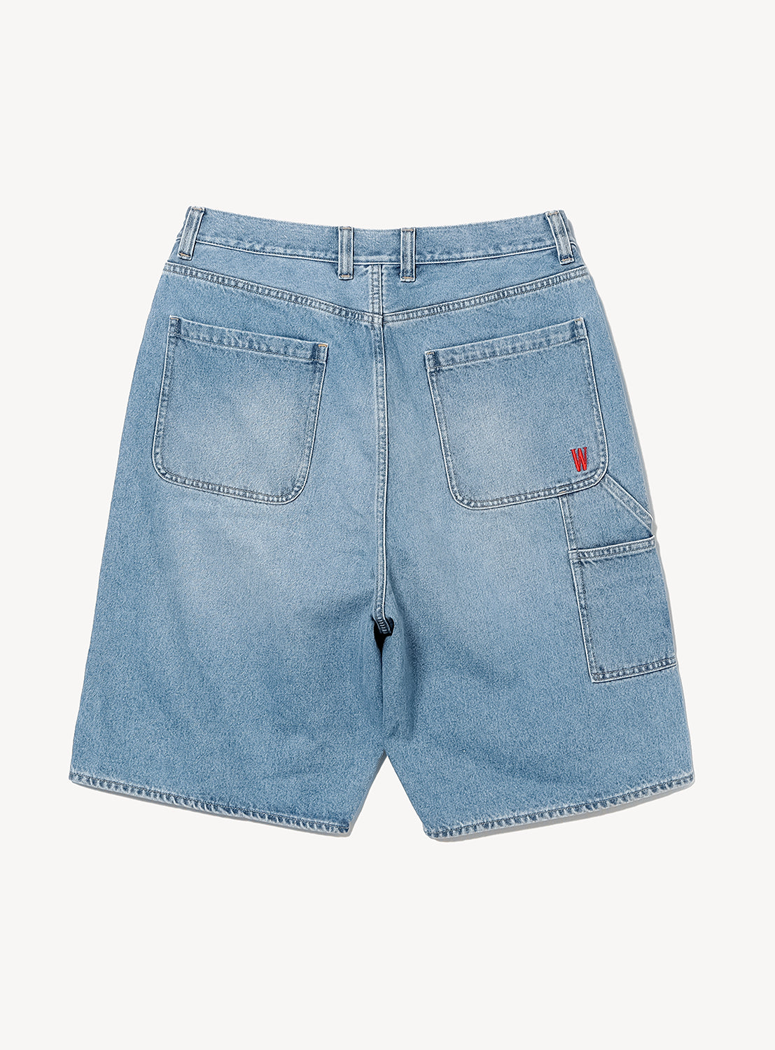 Back view of light blue BEAMS T Tyrrell Winston - Denim Shorts, inspired by classic painter pant style, featuring two large rear pockets, a small red logo on the right pocket, an additional slim side pocket on the right, belt loops, and visible stitching—part of the BEAMS T x Tyrrell Winston collaboration.