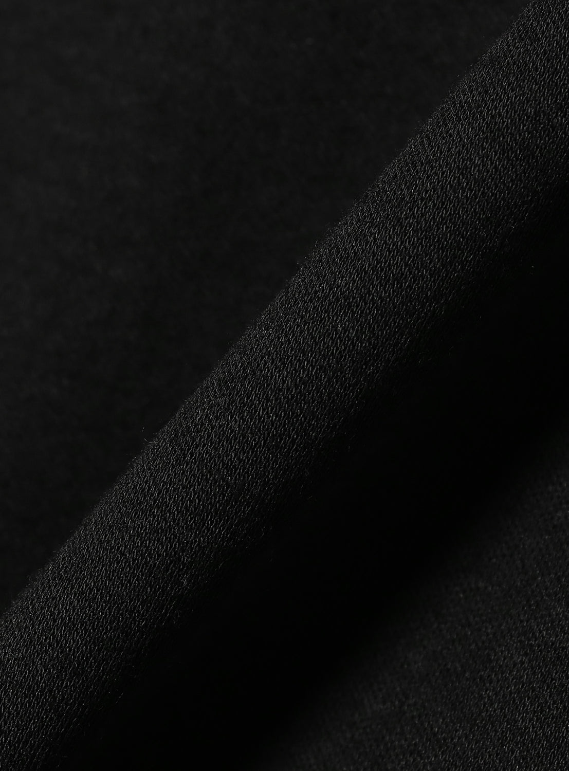 Close-up of the black material, highlighting the quality and subtle texture of the dress fabric.