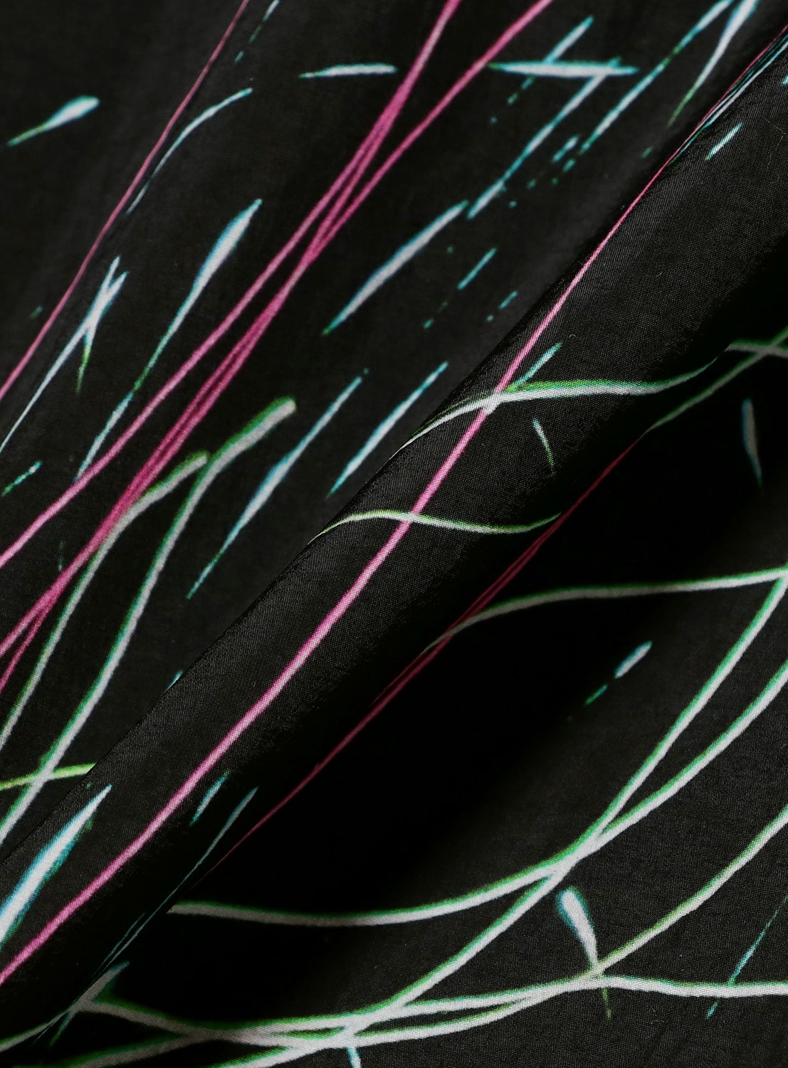 The TEATORA Short Sleeve Cartridge Shirt features black fabric adorned with slender, neon lines in pink, blue, and green, forming an abstract and energetic pattern across the surface. Slightly folded at the center to highlight its wrinkle-resistant properties, this shirt is perfect for hassle-free packing on your travels.