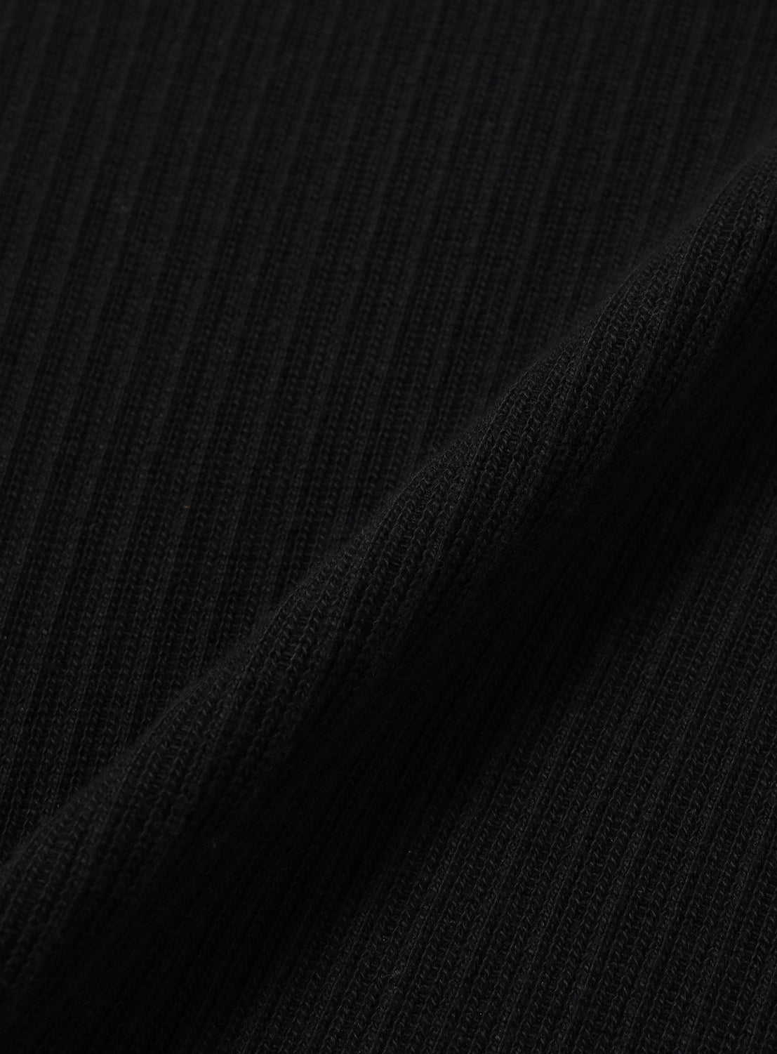 Close-up of a black ribbed BEAMS Henley Neck Long-Sleeve T-shirt with a diagonal fold.