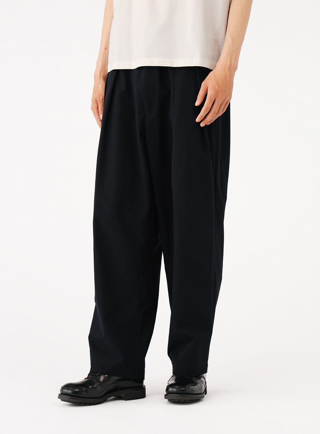 Close-up of a model wearing the navy pants, focusing on the leg length and styling.