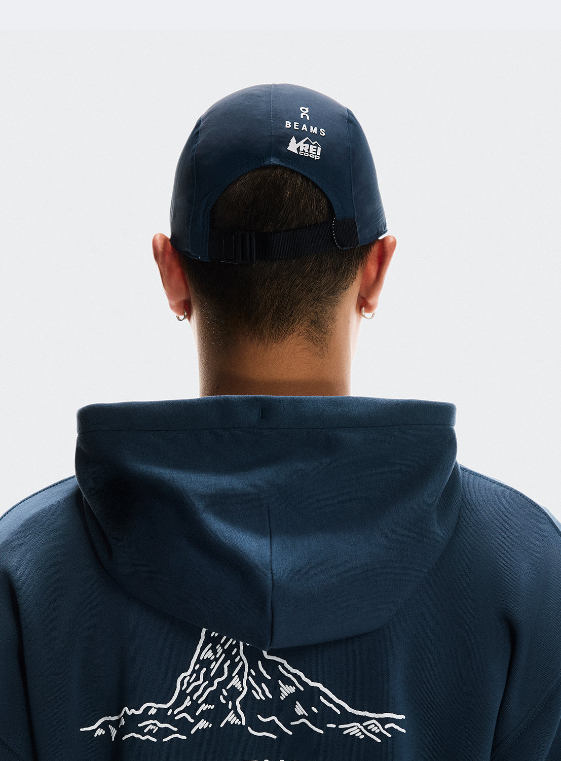Back of navy cap with adjustable strap and BEAMS X ON RUNNING X REI CO-OP logo.