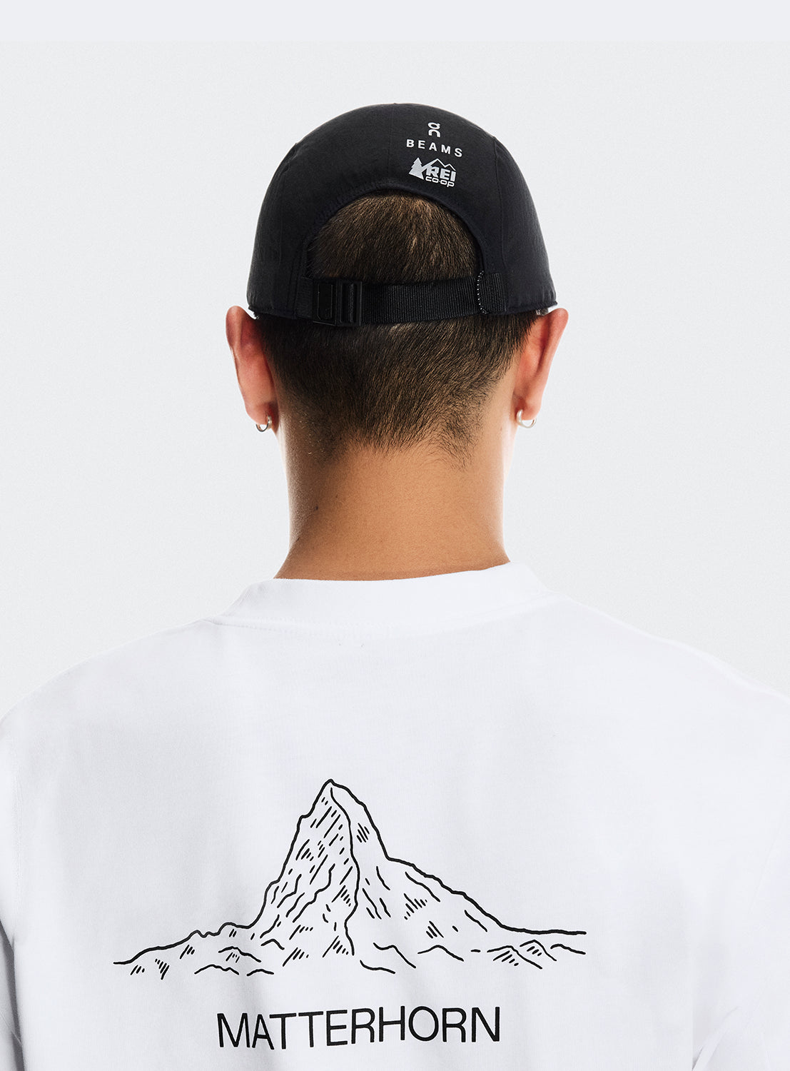 Back of black cap with adjustable strap and BEAMS X ON RUNNING X REI CO-OP logo.