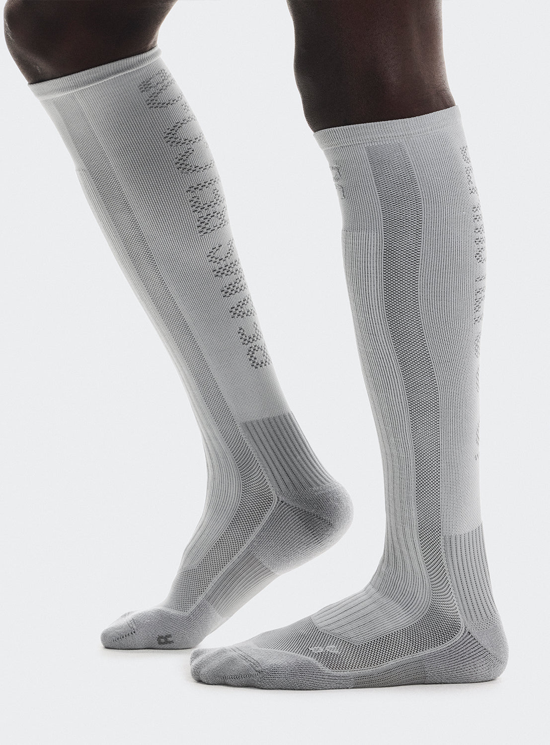 White knee-high socks with text on the back.