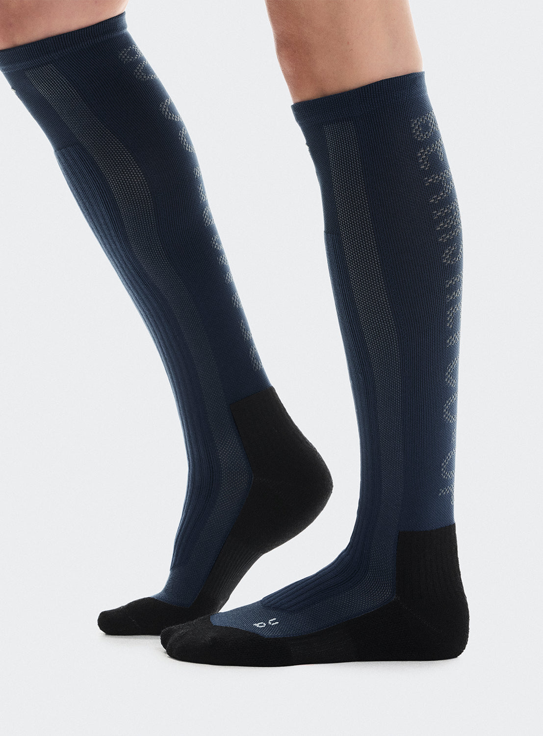 Navy blue knee-high socks with black sole and text on the back.