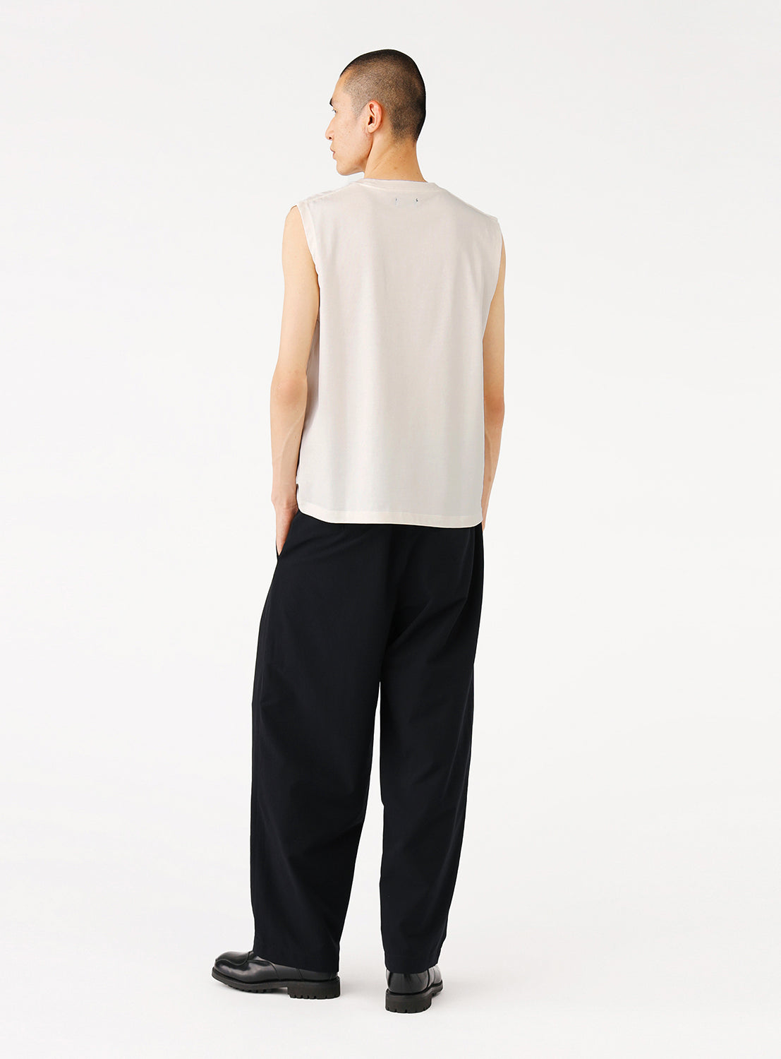 Back view of a model in the navy pants, highlighting the full cut and tailored fit.