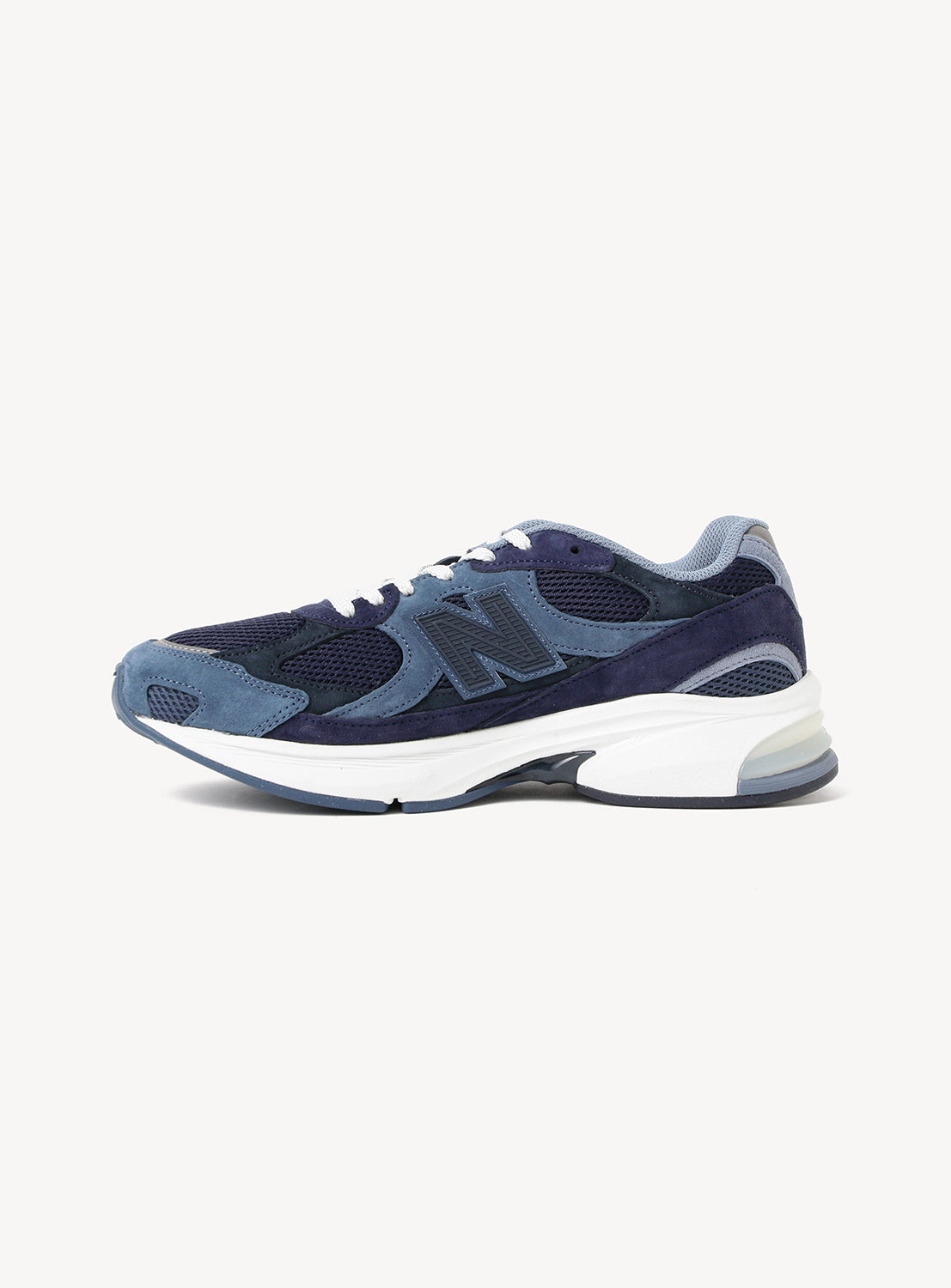 Introducing the New Balance 2010 Exclusive Sneakers by BEAMS—a striking pair of athletic sneakers in navy blue and light blue, featuring mesh and suede detailing, a bold N logo on the side, and a crisp white sole. Built with ABZORB cushioning for superior comfort, this distinctive NEW BALANCE silhouette is showcased against a plain white background.