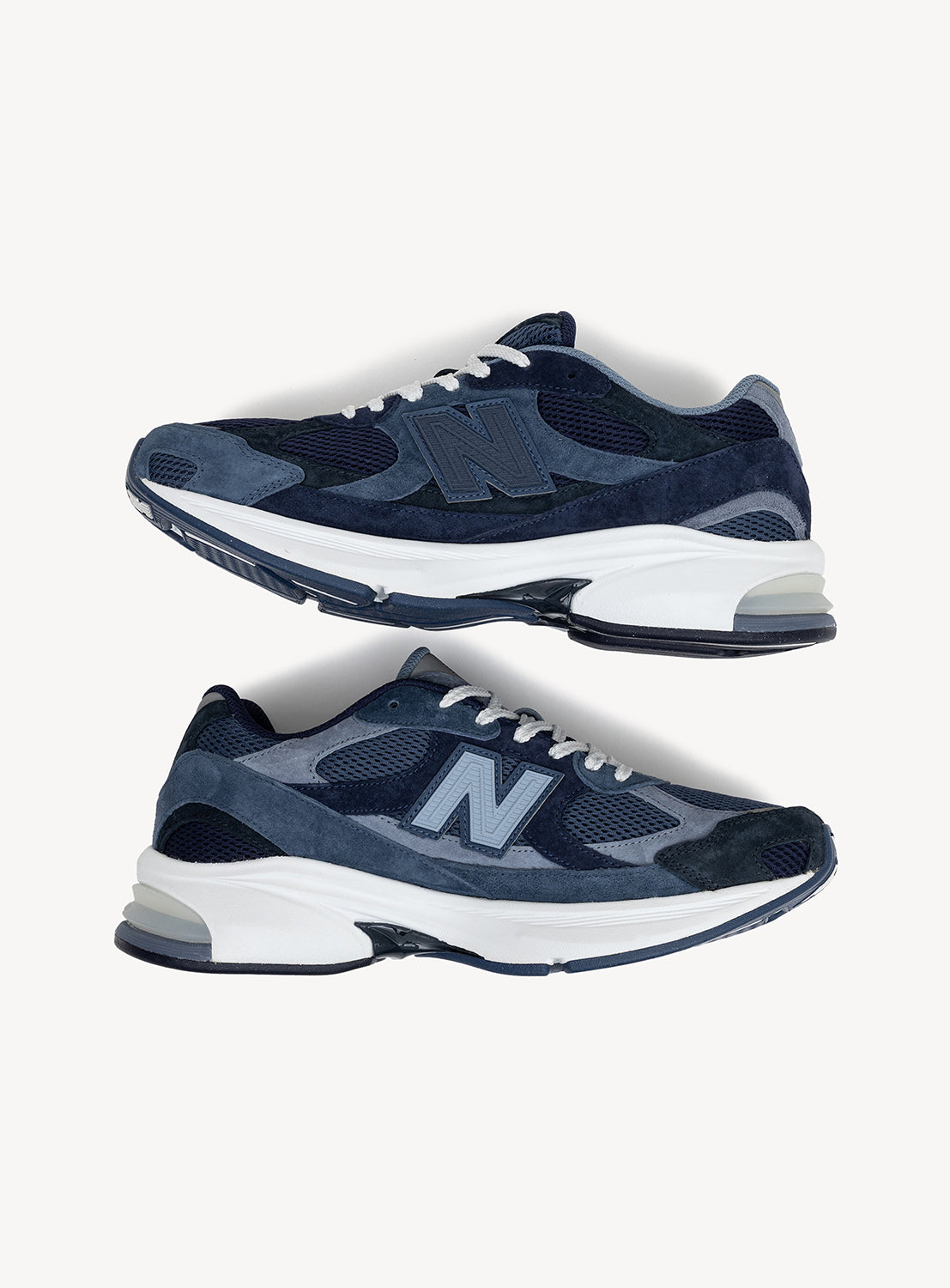 A pair of New Balance 2010 Exclusive Sneakers by BEAMS in navy blue and gray, featuring white midsoles with ABZORB cushioning and dark outsoles, are displayed side by side on a plain white background.