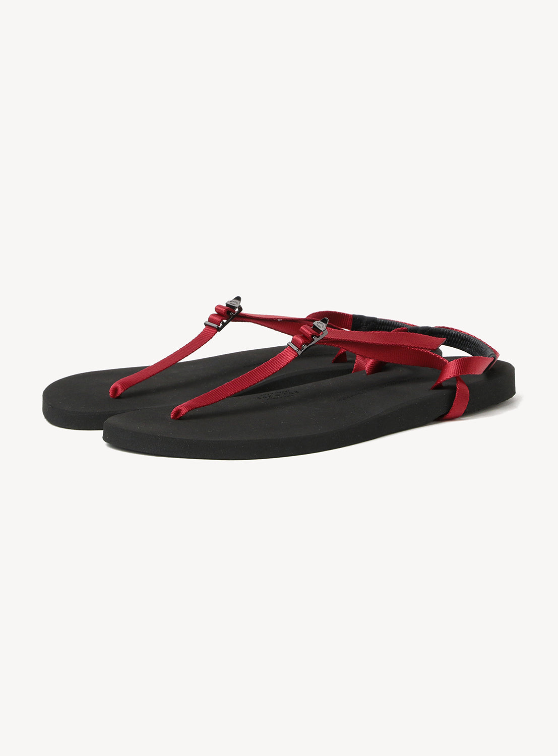 A pair of Minimalist Huarache Barefoot Sandals by BEAUTIFUL SHOES, featuring black soles and thin red adjustable straps, are showcased against a white background.