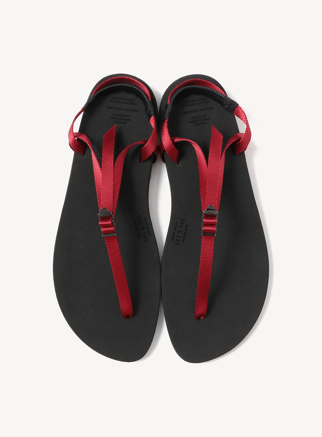 A pair of Minimalist Huarache Barefoot Sandals by BEAUTIFUL SHOES, featuring black soles with red straps, are arranged side by side on a white background, capturing the essence of minimalist footwear.