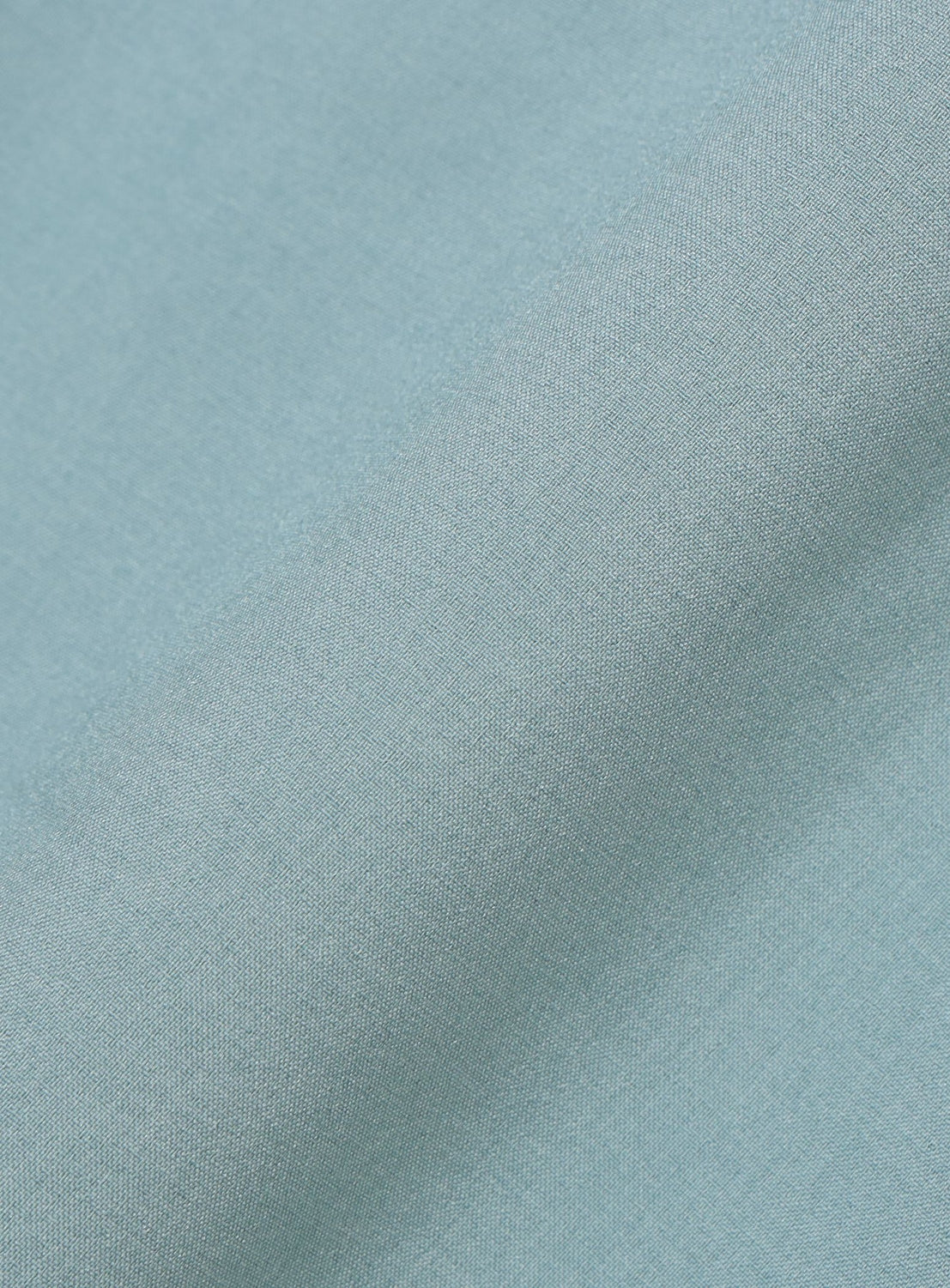 A close-up of light blue performance fabric with a smooth texture and gentle folds, ideal for crafting the BEAMS Wide Fit Double Pocket Contrast Stitch Shirt.