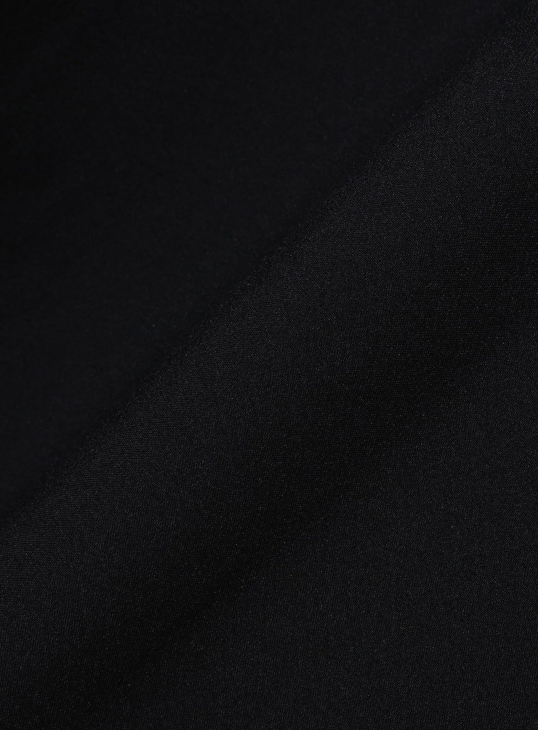 A close-up view of the BEAMS Wide Fit Double Pocket Contrast Stitch Shirt in black, showcasing its performance fabric with a subtle diagonal fold, highlighting the shirt's smooth texture and matte finish.
