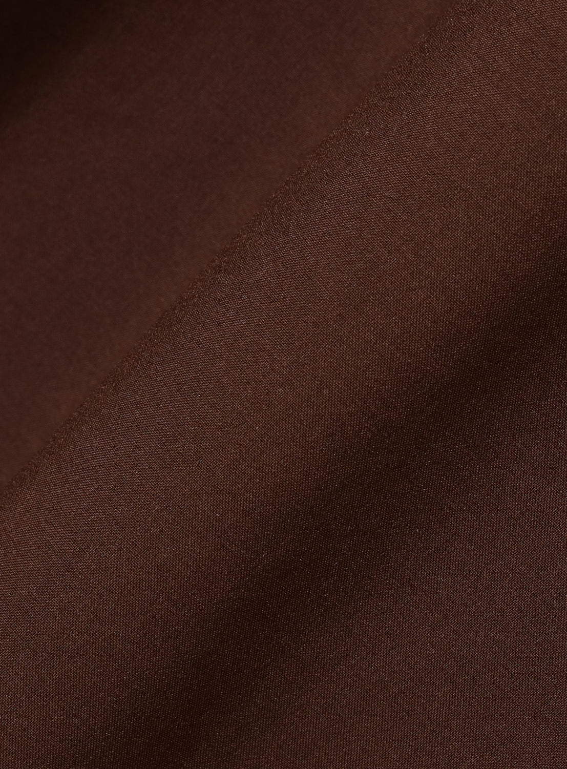 Close-up of the BEAMS Wide Fit Double Pocket Contrast Stitch Shirt, highlighting its smooth brown performance fabric with a matte texture, featuring subtle diagonal folds, fine weave details, and soft shadows.