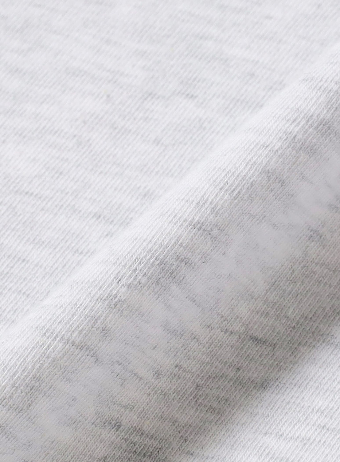 Close-up of the Kensei Yabuno T-shirt by BAL in light gray fabric, featuring a subtle heathered texture and fine woven fibers with a soft, gently folded surface—an ideal canvas for showcasing creative expression through art-driven design.