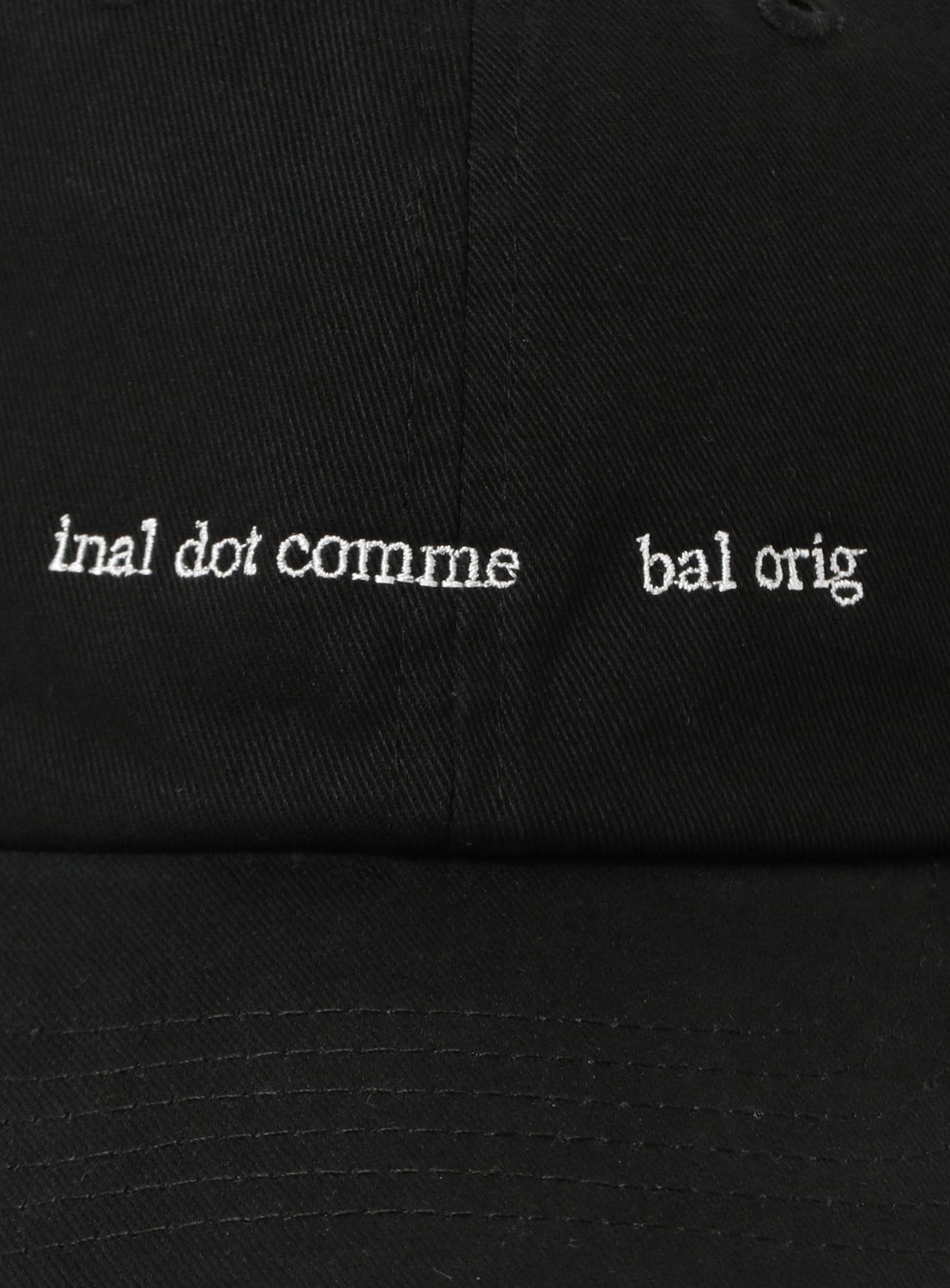 Close-up of the BAL Cotton 6-Panel Hat in black cotton twill, featuring white embroidered "lnal dot comme bal orig" text in a serif font and a low-profile silhouette.