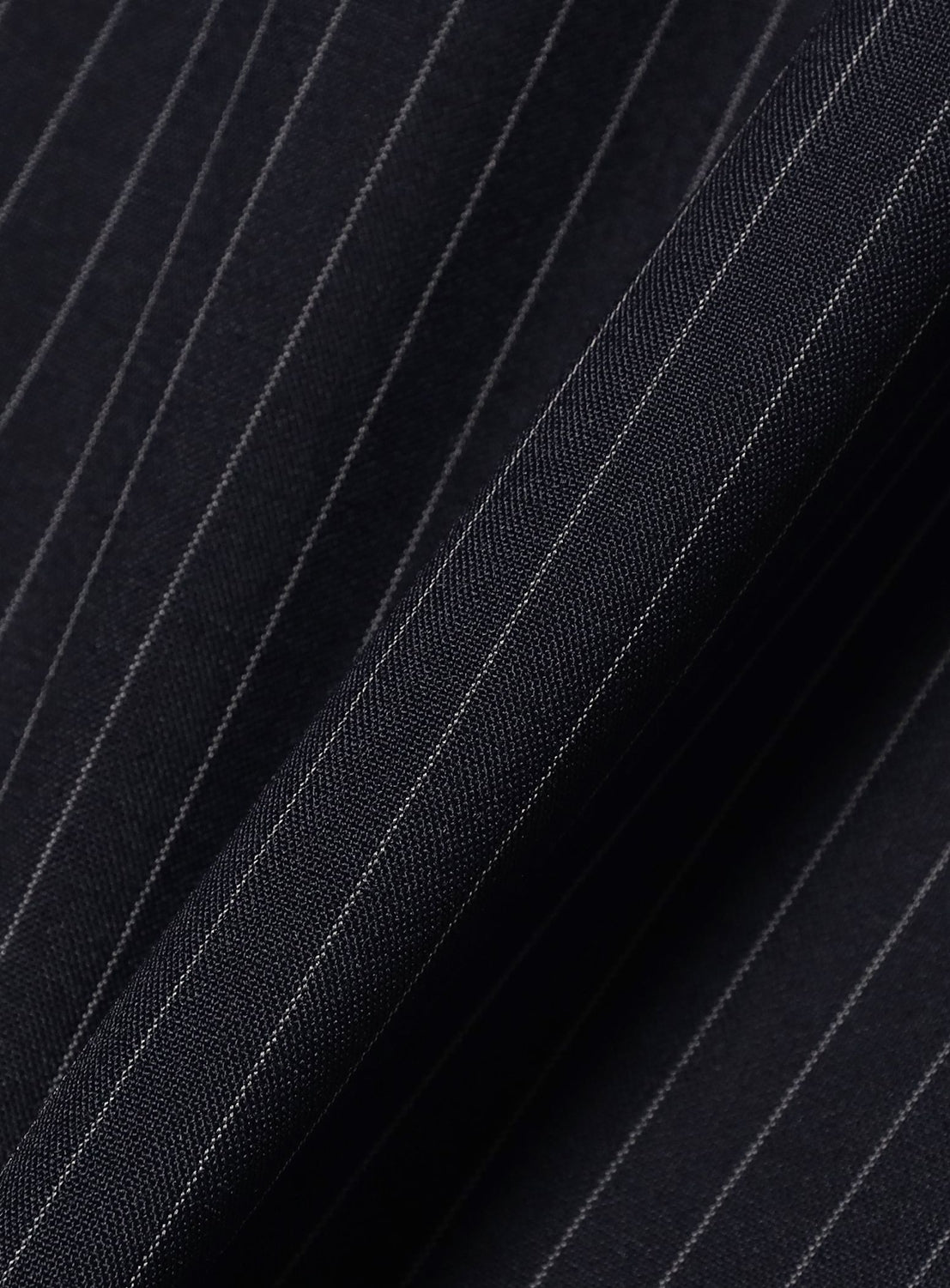 Close-up of the BEAMS TW Wide Fit Half-Zip Shirt, featuring dark polyester-wool tropical fabric with fine vertical white pinstripes, highlighting its smooth texture and gentle folds in the material.