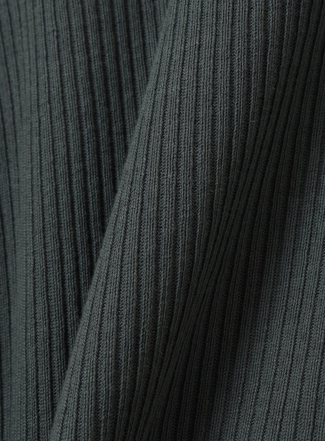 Close-up of dark ribbed fabric with vertical textured lines, featuring soft folds and a subtle sheen—ideal for the BEAMS Short Ribbed Polo Shirt in its cropped silhouette.