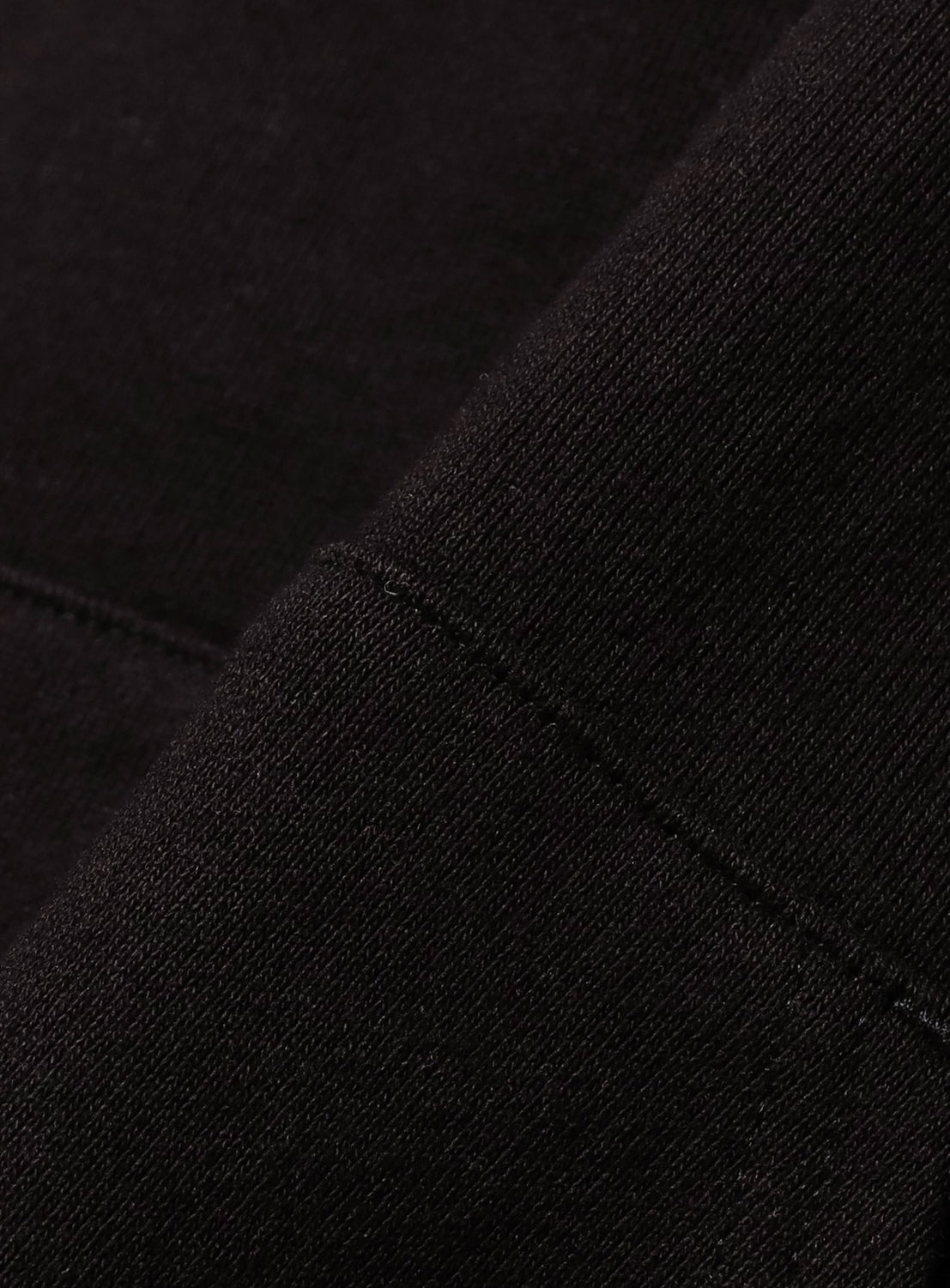 Close-up of BEAMS Color Block Heavyweight Fleece Hoodie fabric, featuring visible stitching and a diagonal seam that highlights the texture and weave of the material.