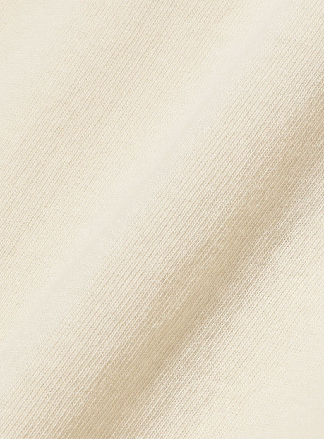 Close-up of the BEAMS BOY Wide Border Lace-Up Short Sleeve Top shows its cream-colored, textured fabric with a diagonal weave and bold knit-like design, while soft shadows accentuate its distinctive look.