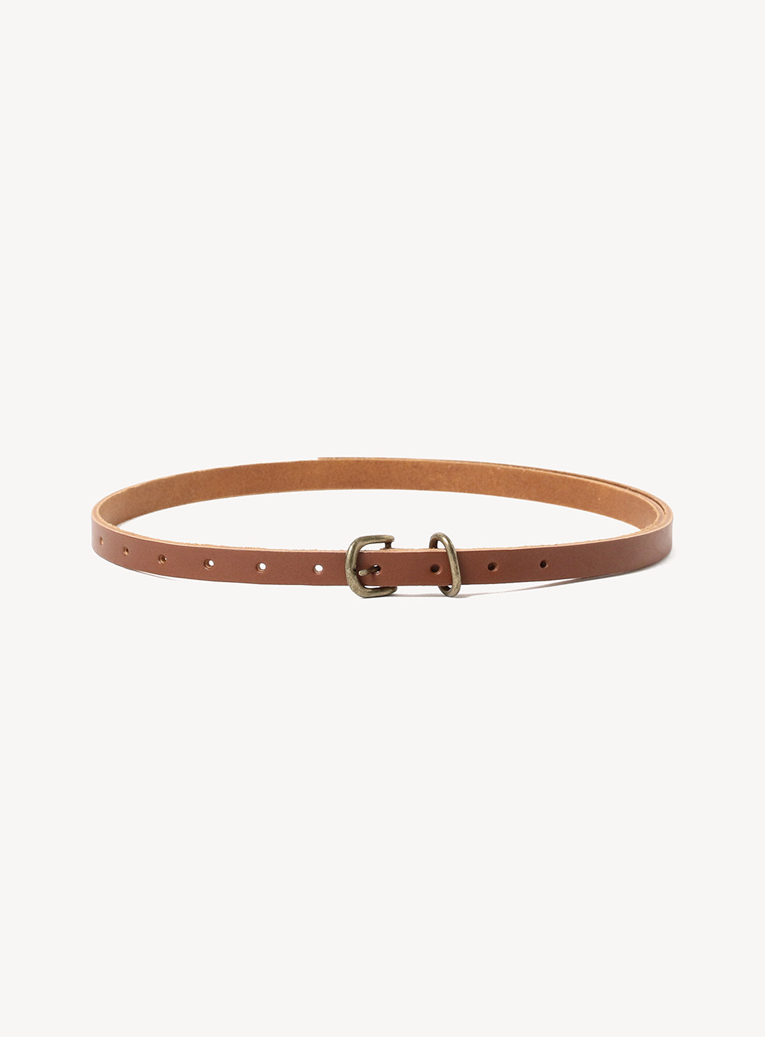 The Extended Belt by Hender Scheme, made from vegetable-tanned brown cow leather with a small metal buckle, is shown laid flat on a white background.
