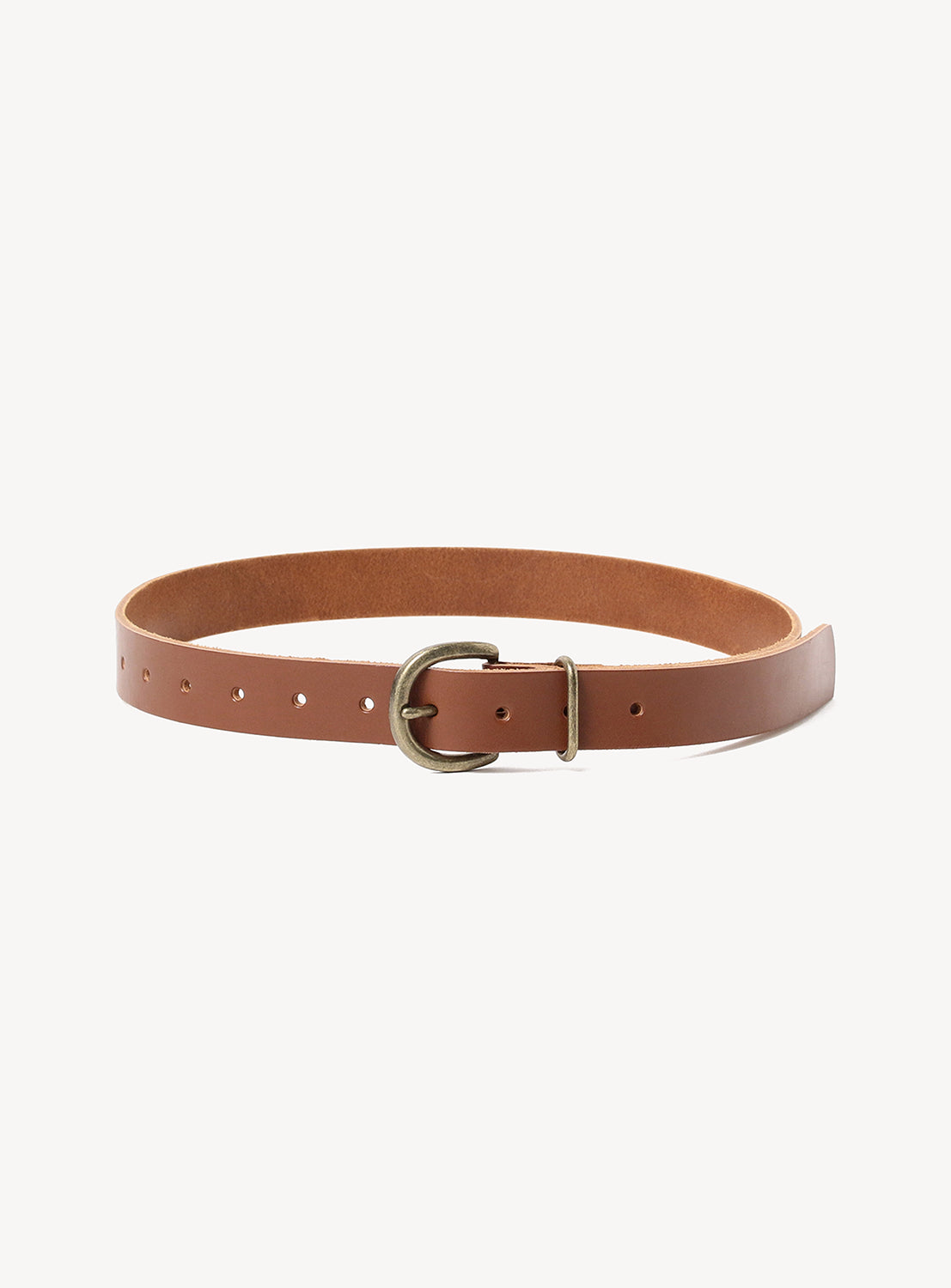 The Hender Scheme Tanning Belt, made of brown cow leather with a brass buckle, is displayed in a circular shape on a white background to highlight its durable construction.