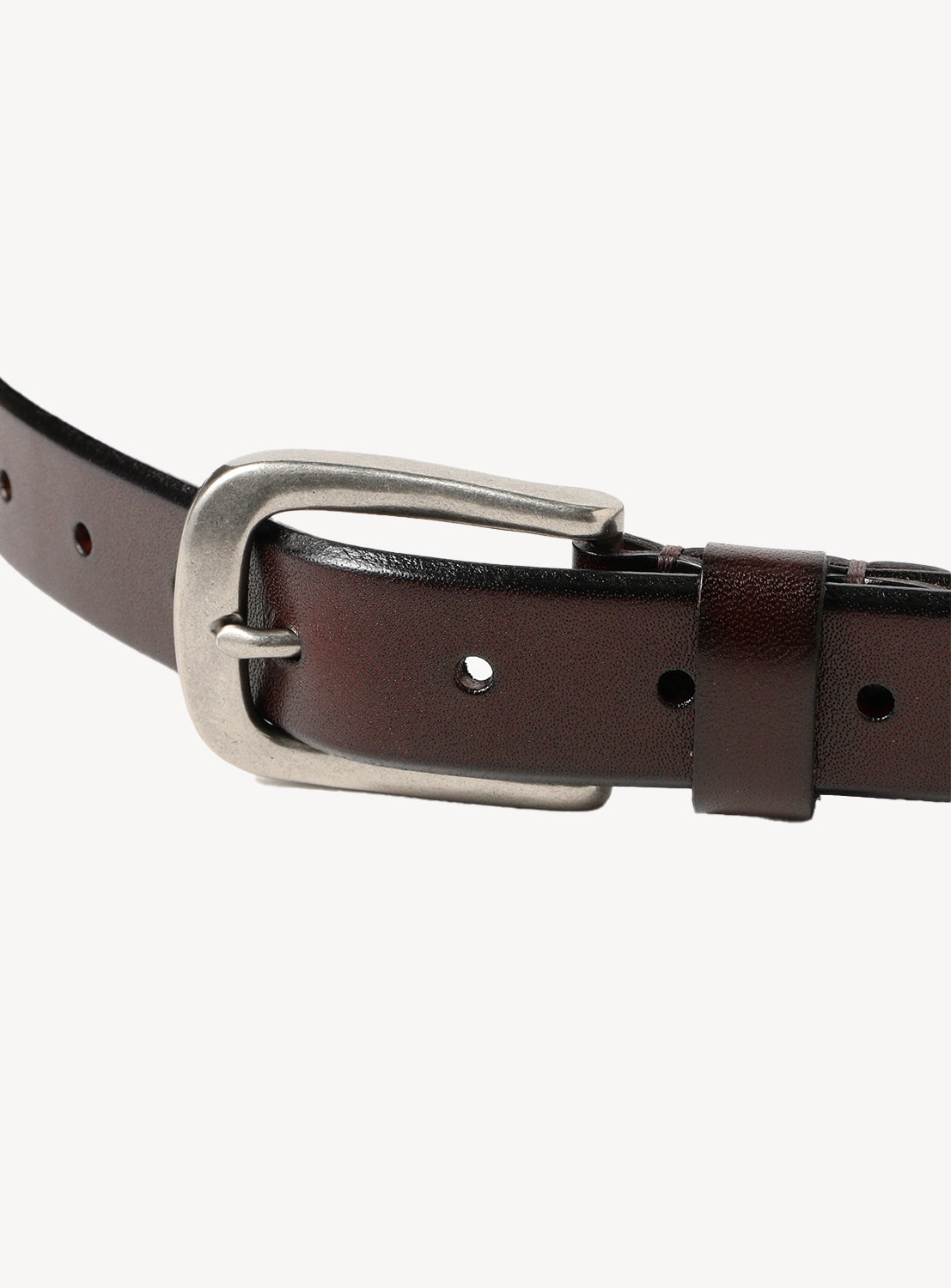 Close up of brown Brazilian tanned leather belt with a silver buckle. 