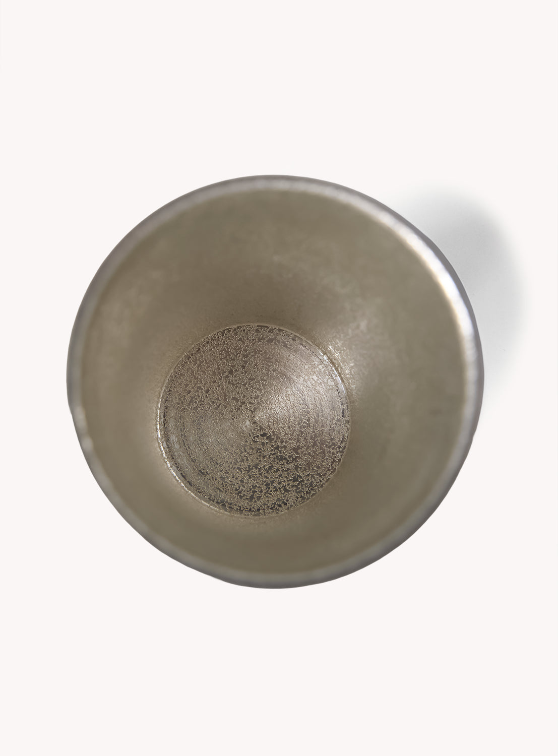 A top-down view of the SATSUMA x BEAMS JAPAN Smart Tumbler—an empty metallic cup with a textured interior, casting a subtle shadow on a white background. Expertly crafted and Made in Japan, this elegant BEAMS JAPAN tumbler reflects refined Japanese aesthetics.