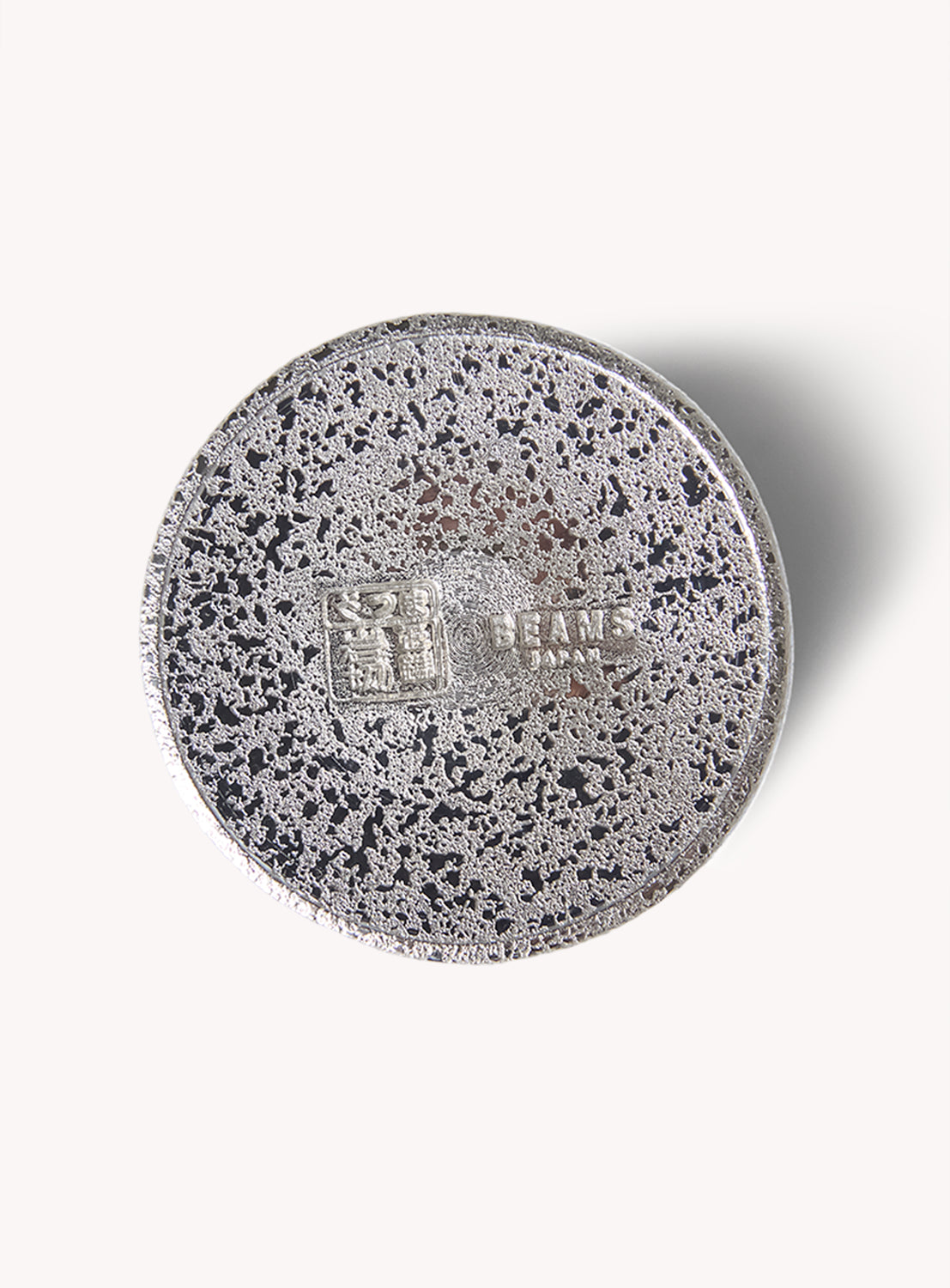 A round, speckled silver SATSUMA x BEAMS JAPAN Smart Tumbler with a textured surface and embossed logos at its center—echoing the timeless style of classic Satsuma tinware—is showcased from above against a plain white background. This exquisite piece from BEAMS JAPAN is proudly Made in Japan.