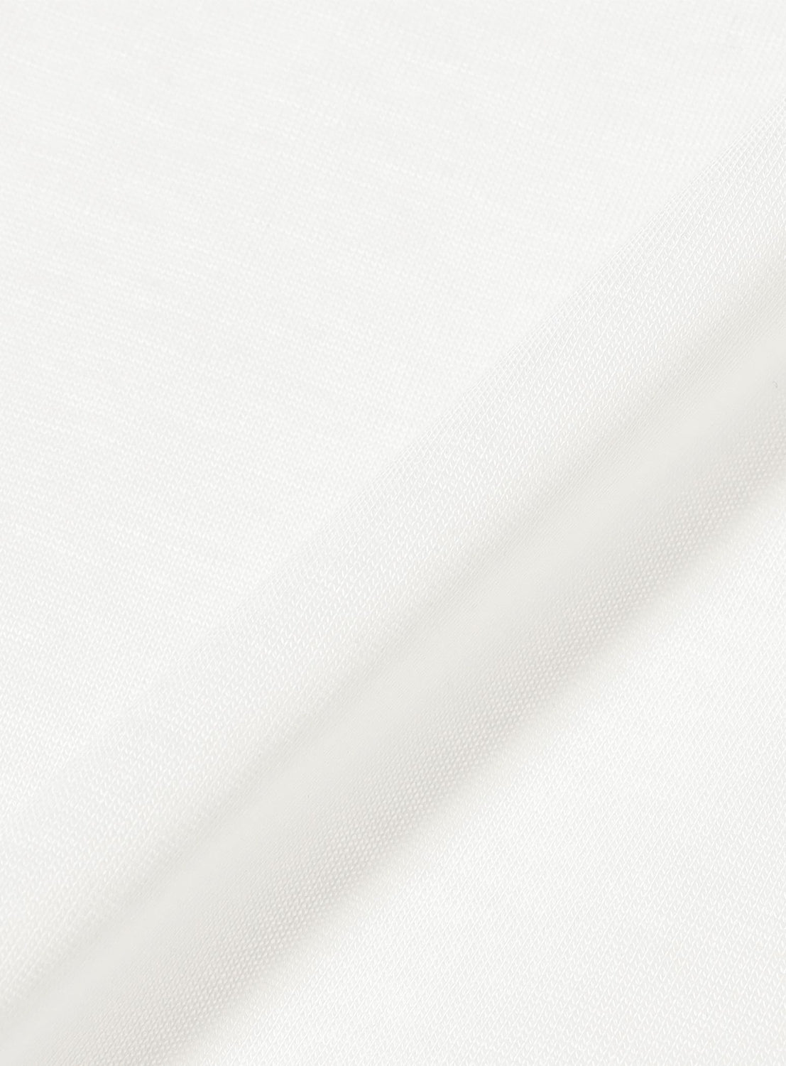 Close-up of a folded piece of plain white fabric with a subtle woven texture, displayed on a light background with soft shadows along the crease—perfect for crafting the Bowie T-Shirt by COG THE BIGSMOKE, known for its effortlessly voluminous silhouette.