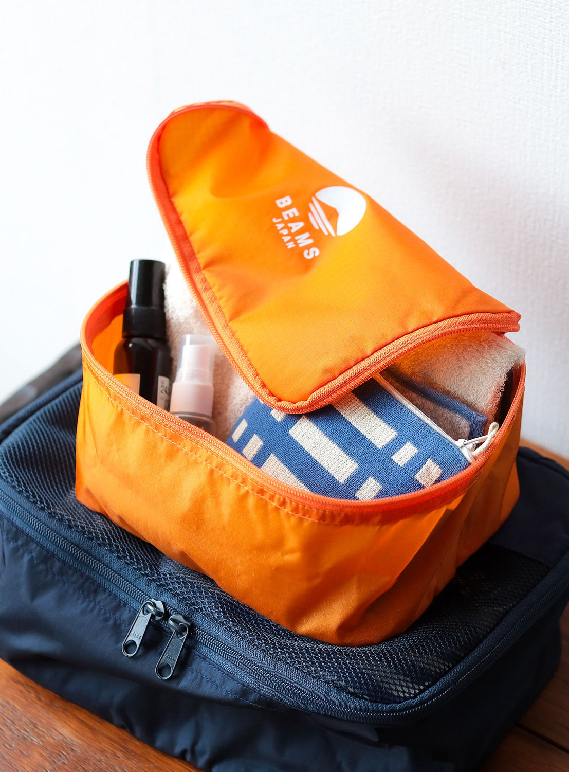 Orange travel organizer with items inside on a white background