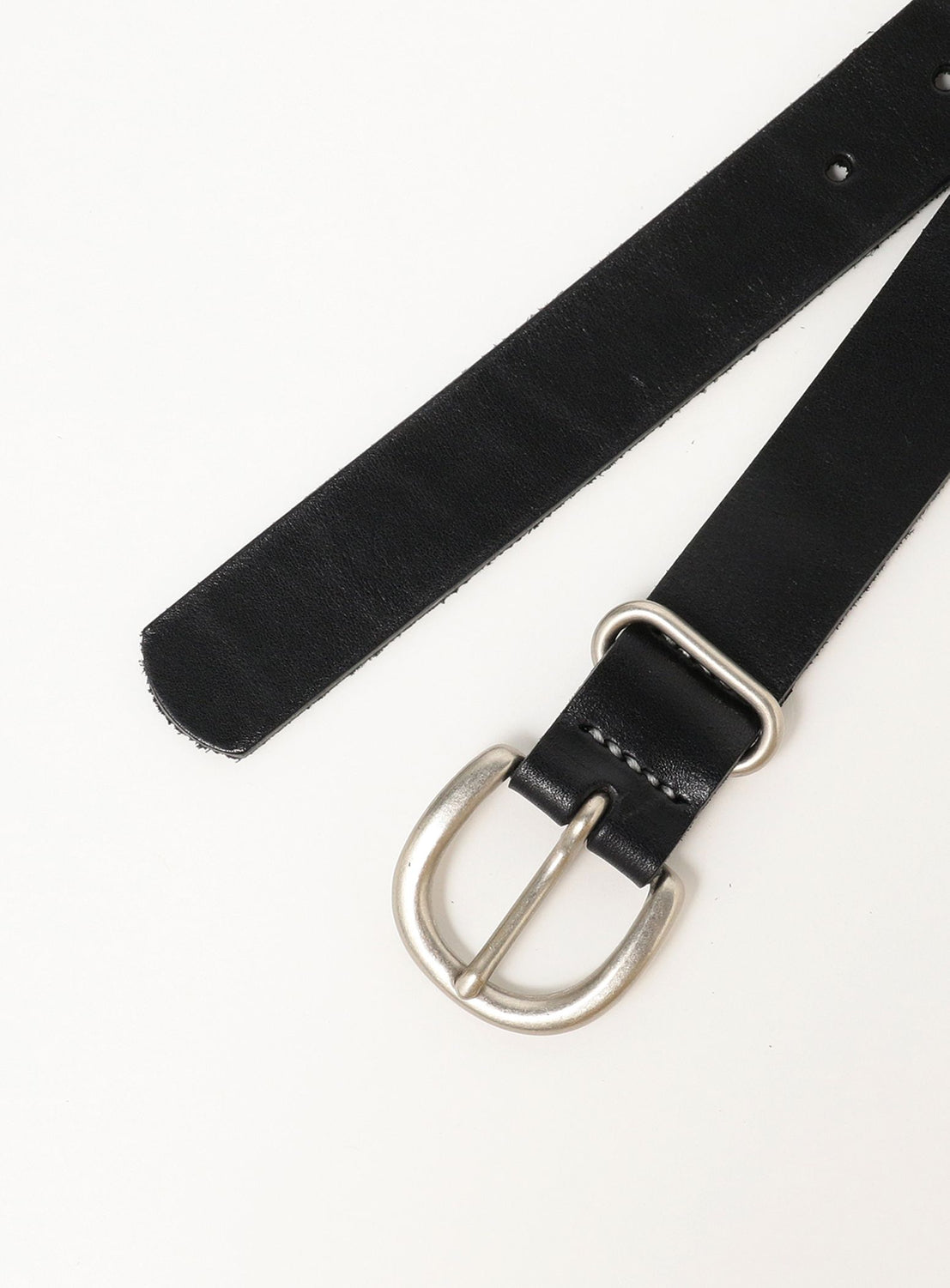 The Hender Scheme Tanning Belt, made from premium black cow leather and finished with a silver buckle, is displayed flat on a white surface with its end extending diagonally upward.