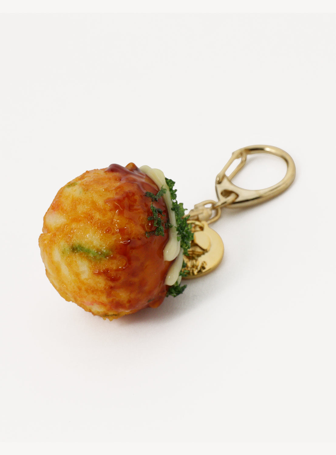 The [Exclusive] BEAMS JAPAN Sample Kobo Realistic Food Sample Keychain - Vol. 1 by BEAMS JAPAN features a meticulously crafted takoyaki (Japanese octopus ball) charm, topped with lifelike sauce, mayonnaise, and seaweed details. Finished with a gold-colored metal clasp, this handmade keychain is a unique Japan souvenir inspired by Gujo Hachiman, beautifully presented against a clean white background.