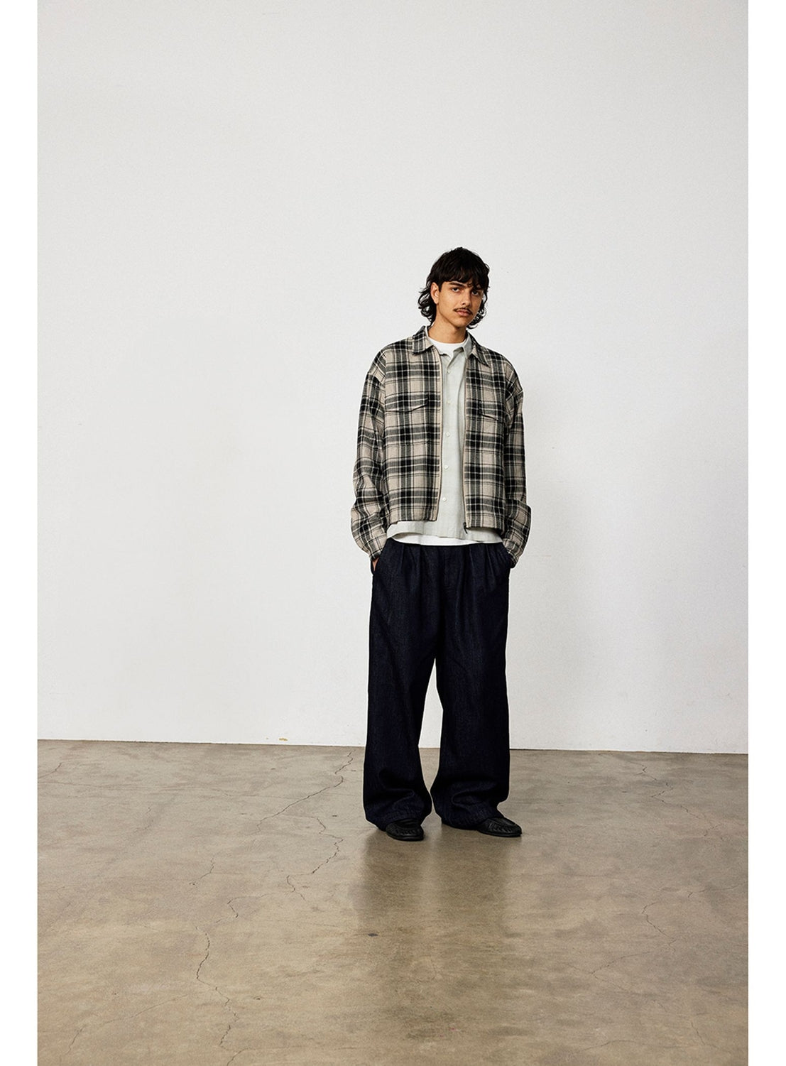 A person wears a BEAMS Classic Check Mesh Zip-Up Shirt over a light-colored top, paired with wide-leg dark trousers in a relaxed silhouette.