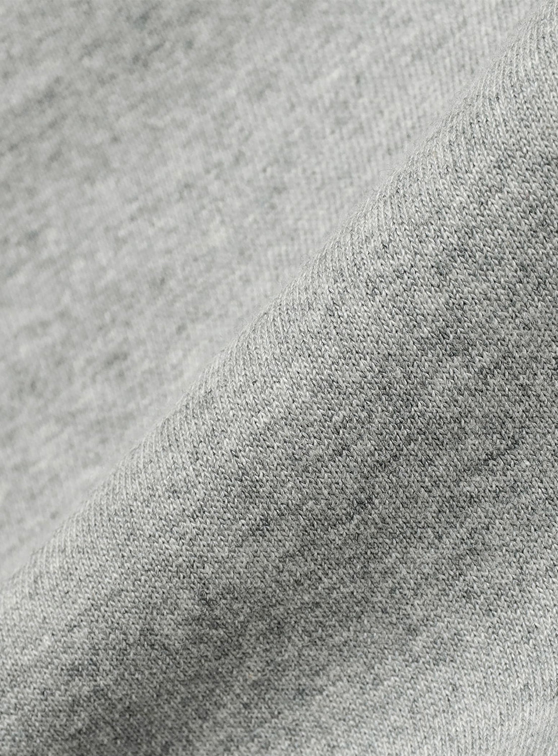 Close-up of light gray, lightweight jersey fabric with a soft, textured weave—featured in the [Exclusive] Champion Reverse Weave® Wide-Leg Shorts by CHAMPION, perfect for crafting wide silhouette or knee-length styles.