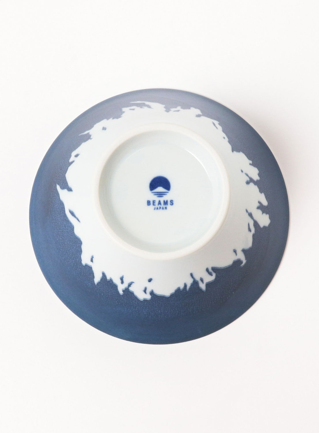 Blue ceramic bowl with white interior and brand logo on a white background