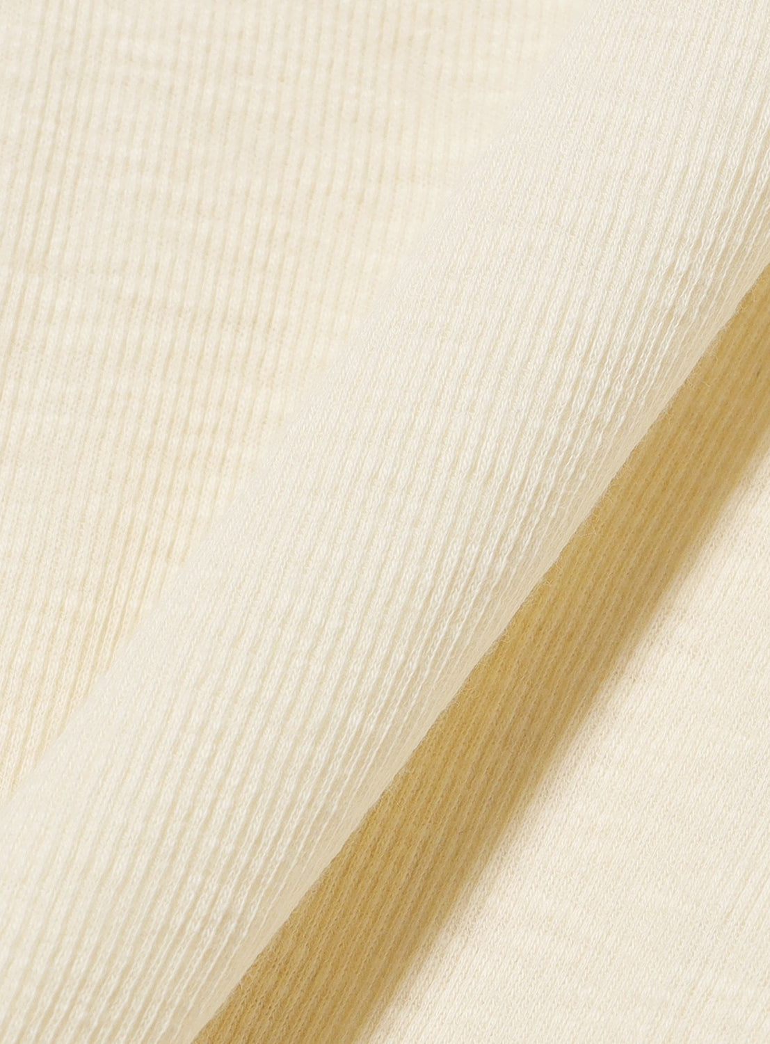 Close-up of the BEAMS BOY Layered Rib Tank Top in cream, showcasing its vertically textured ribbed fabric with a soft and smooth finish. The material is folded diagonally across the image, highlighting the garment’s signature rib knit detail.
