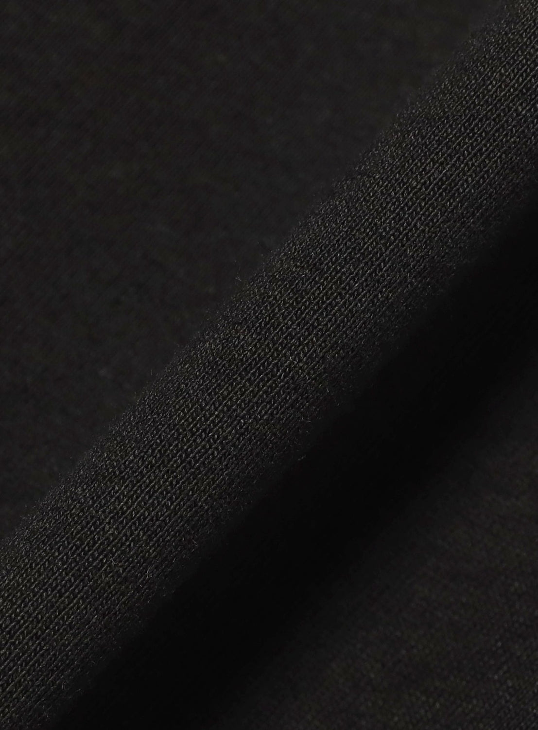 Close-up of the F-LAGSTUF-F Symbol Logo Tee, showing heavyweight cotton fabric with a fine ribbed texture and weave pattern, plus a slightly folded edge.