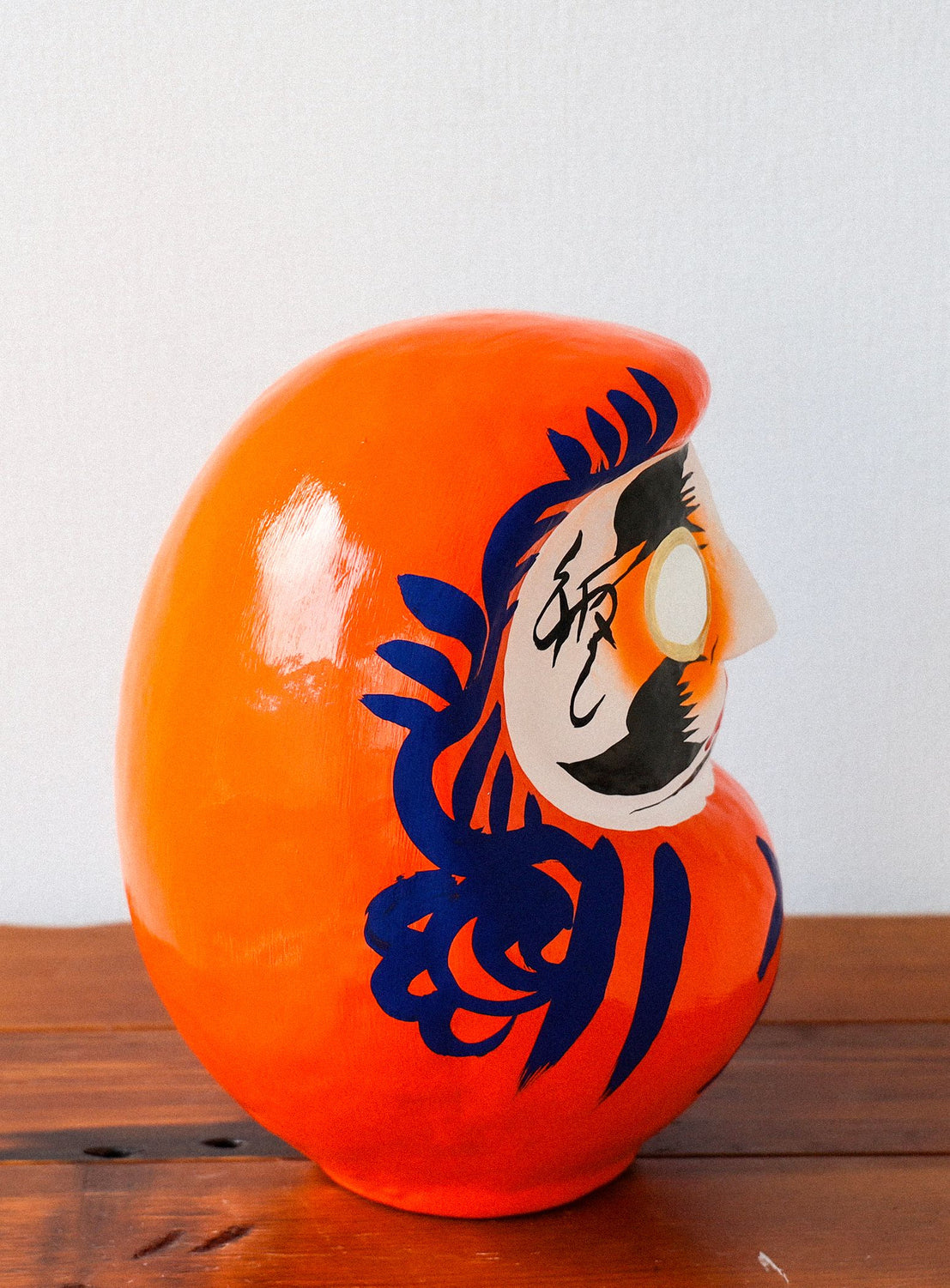 Orange decorative item with a face design on a wooden surface