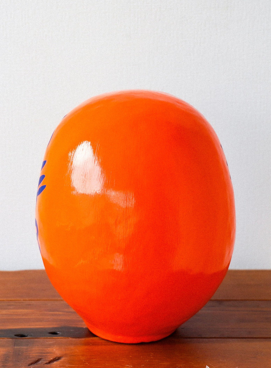 Orange ball with blue design on a wooden surface and white background