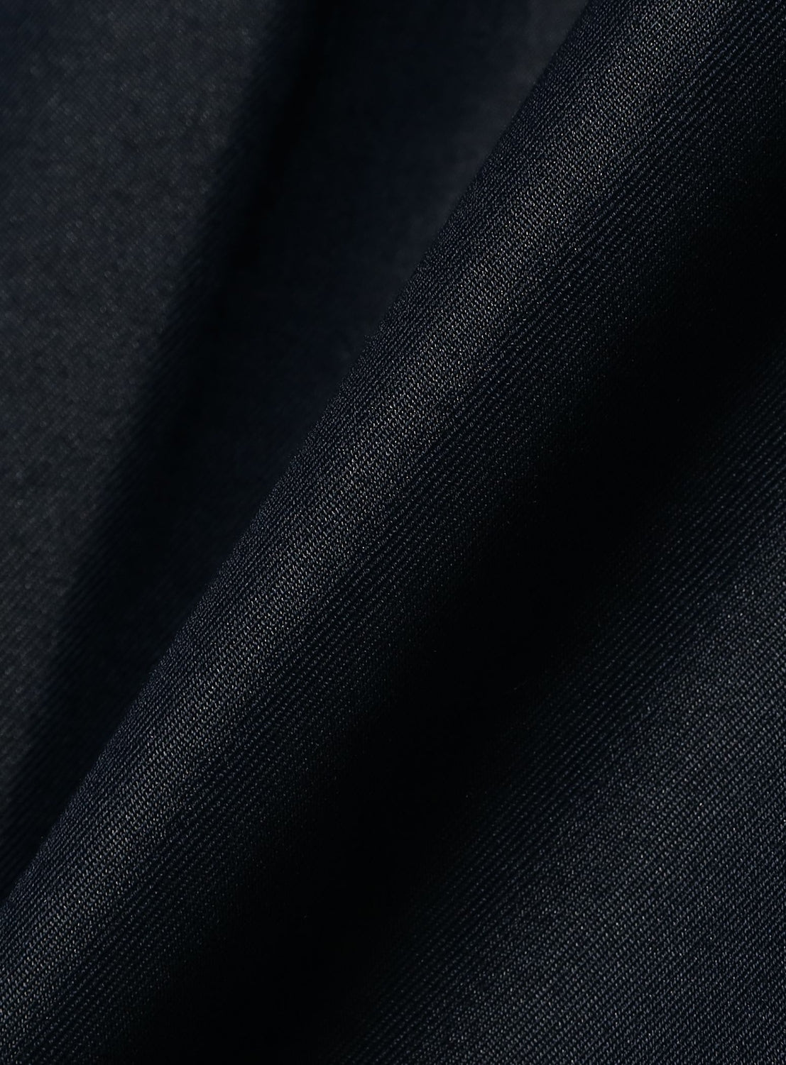 Close-up of the dark blue chambray fabric of BEAMS Chambray Chino Pants, showing a visible diagonal weave.