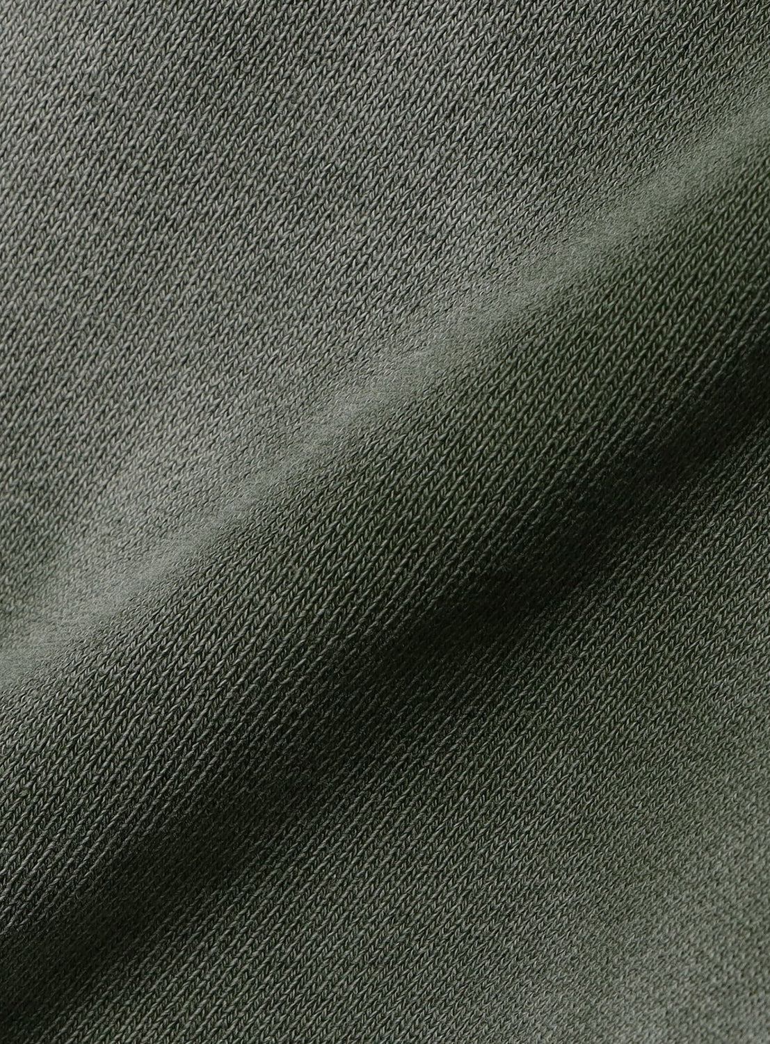 Close-up of the BEAMS Faded Rivet Full-Zip Wide Short Fit Hoodie in olive green shows its visible weave texture and gentle folds, enhanced by soft shadows and highlights for a classic, vintage-inspired look.
