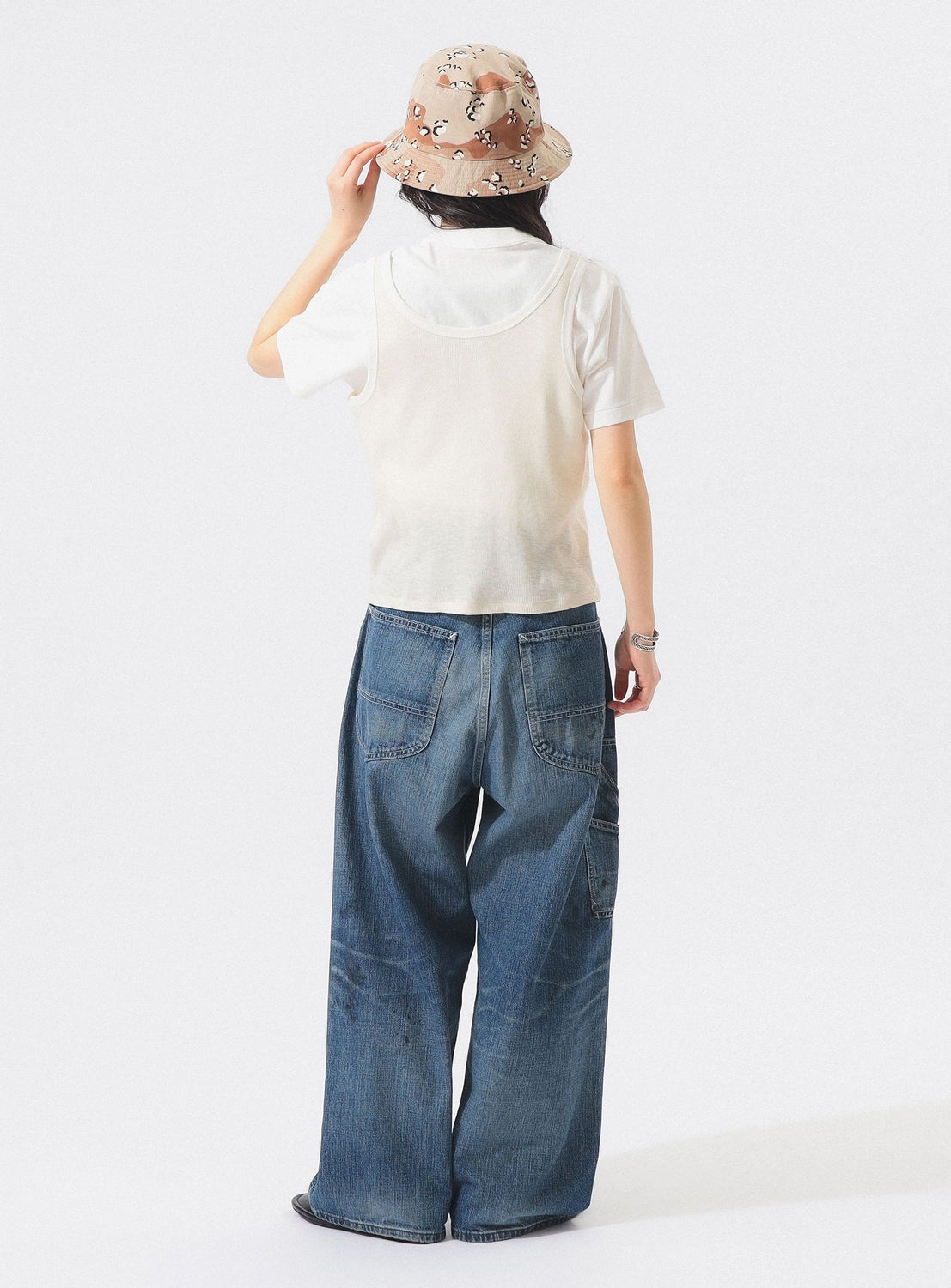 A person facing away, wearing a beige patterned bucket hat, the BEAMS BOY Layered Rib Tank Top, loose blue jeans, and a watch, stands against a plain white background.