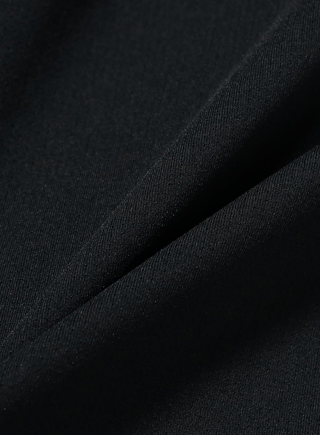 A close-up view of the BEAMS Dynamic Dry Wide Fit Shorts, featuring black, quick-drying fabric with a visible diagonal weave pattern and a soft fold running through the center.