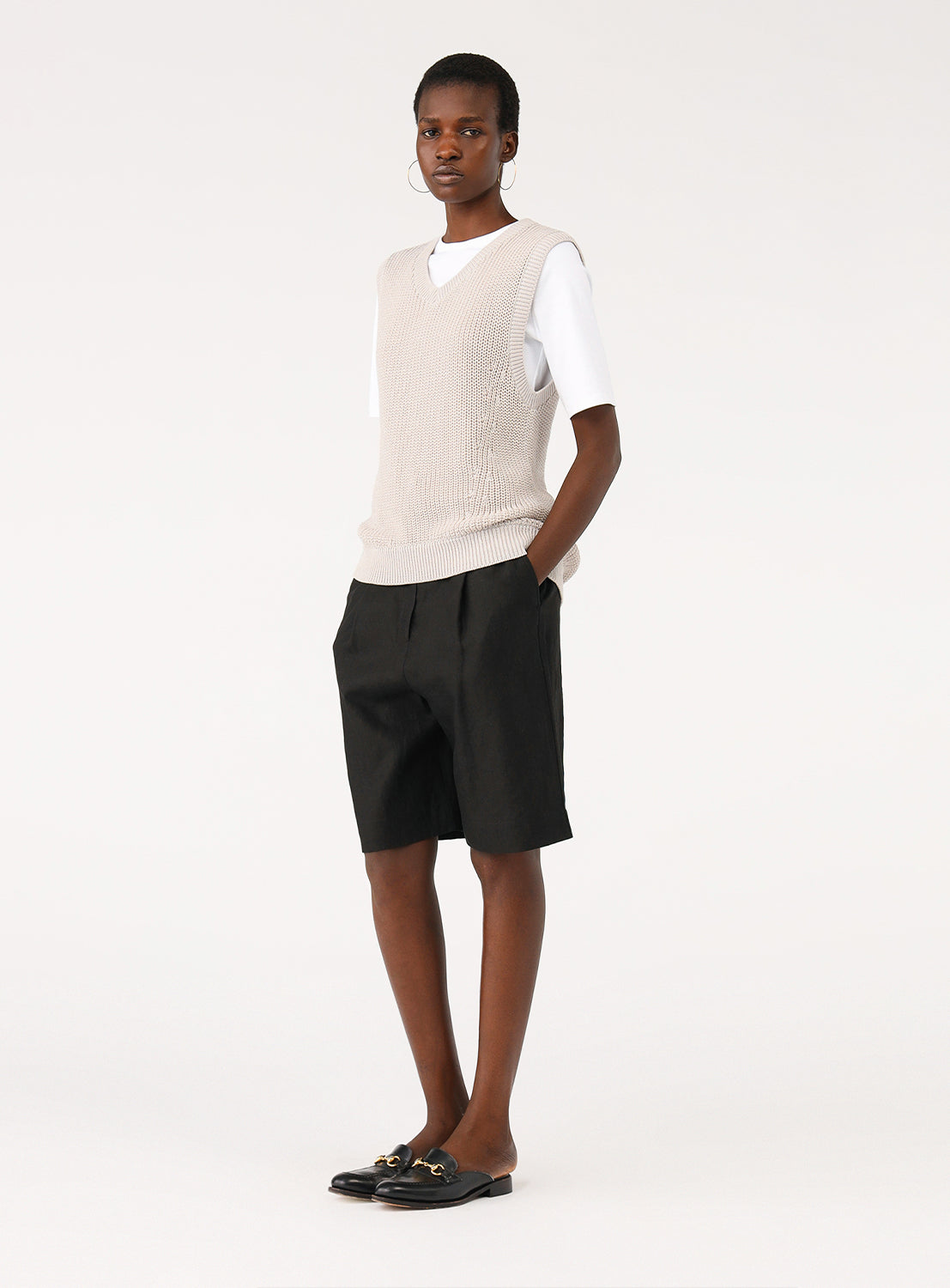Model demonstrating the fit of the light grey V-neck vest, styled for a relaxed, casual look
