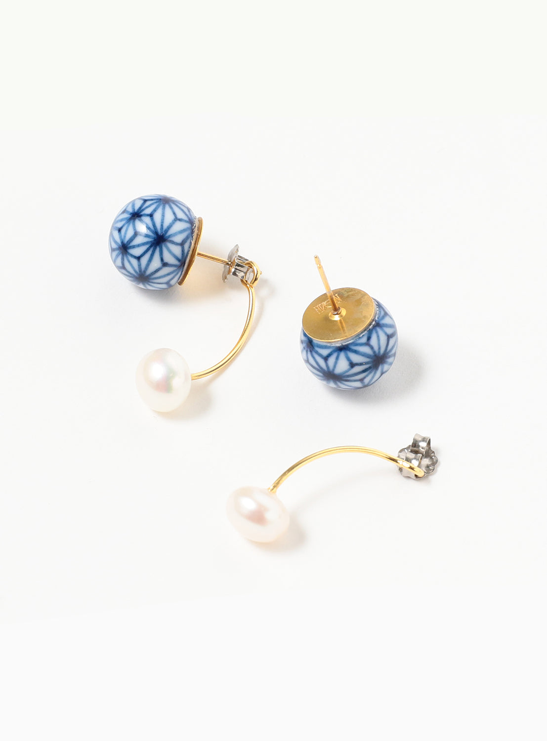 The Arita Ware Dangling Motif & Pearl Earrings by Hizen Jewelry feature blue patterned Arita porcelain ceramic studs, elegant gold curved bars, and white freshwater pearls at the ends, shown on a white background—a stunning example of Japanese handcrafted jewelry.