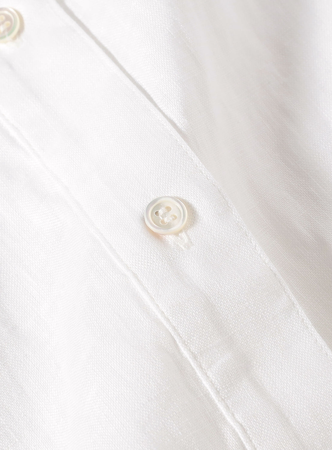 Close up of the white buttons on the button down shirt.