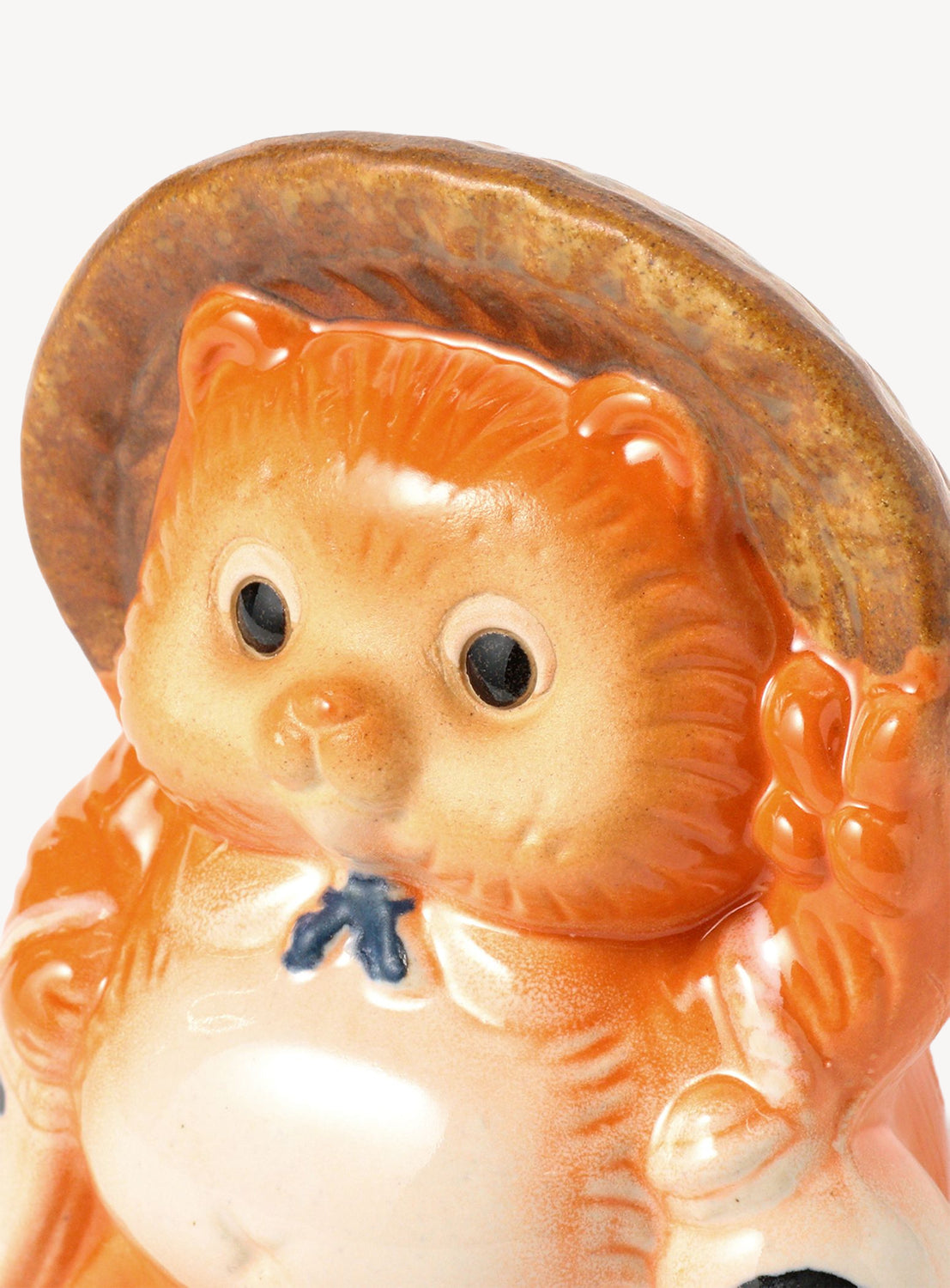 Ceramic bear figurine with a straw hat on a white background
