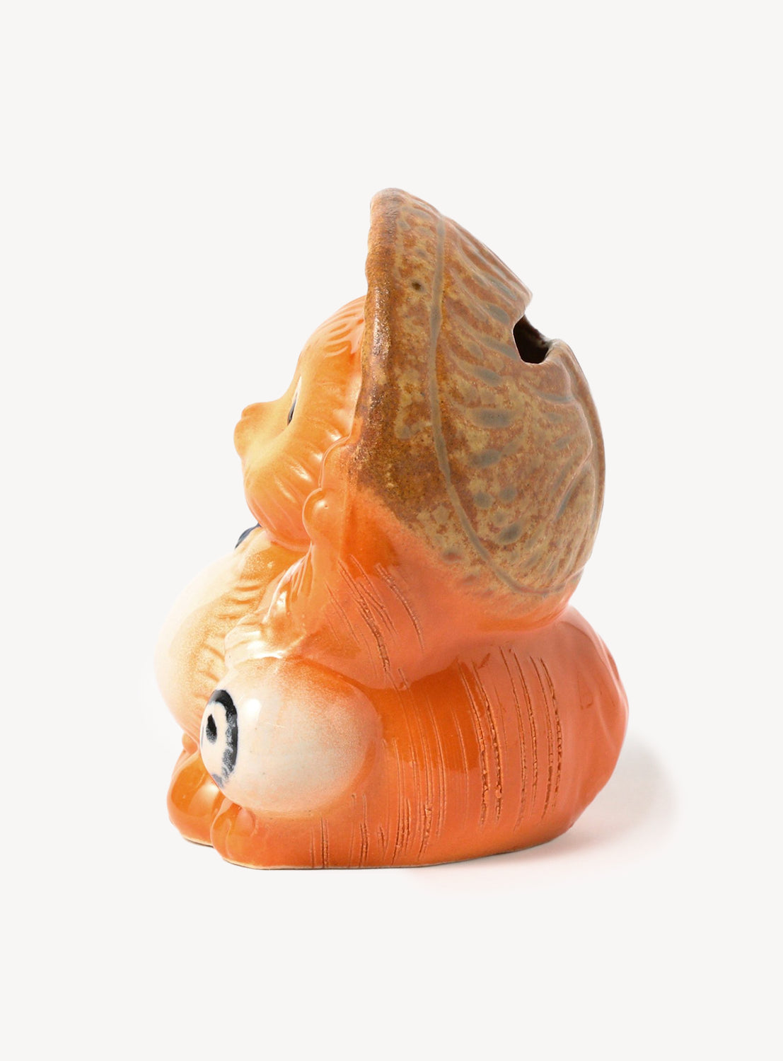 Seashell-shaped object with a face on a white background